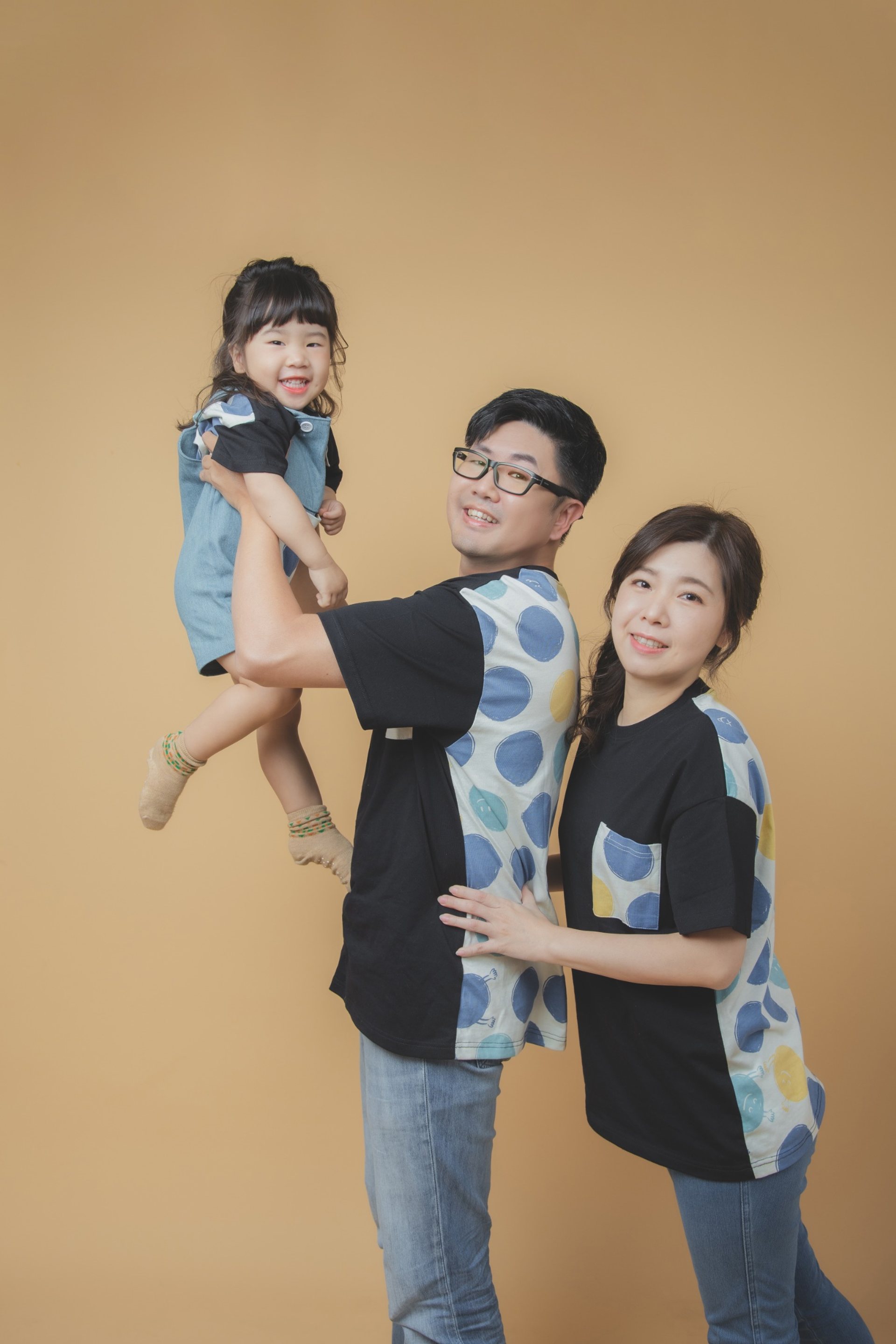 全家福寫真－三口之家親子裝米色背景爸爸高舉女兒