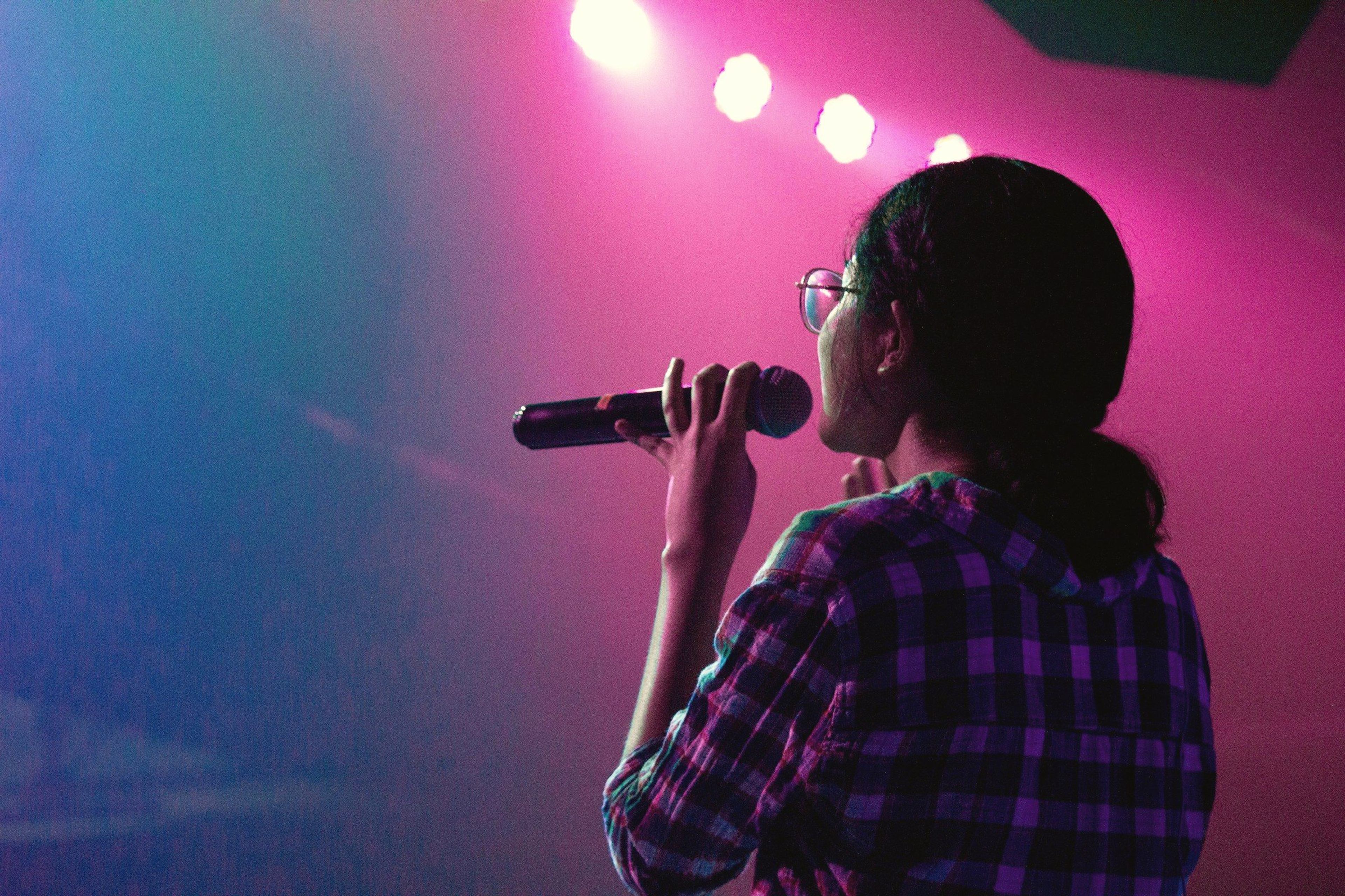 A singer with a microphone under stage lights