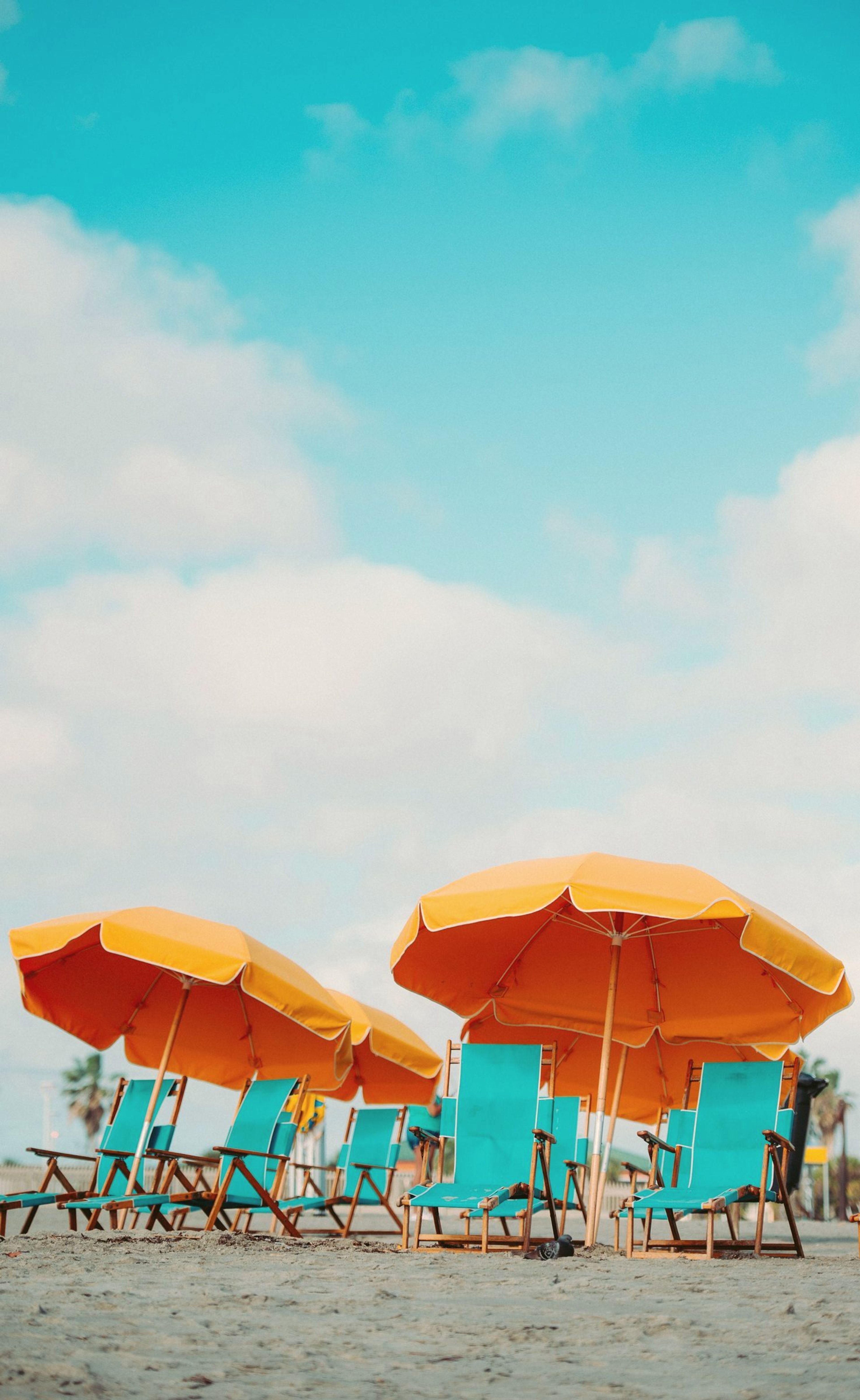 Loungers under orange beach umbrellas