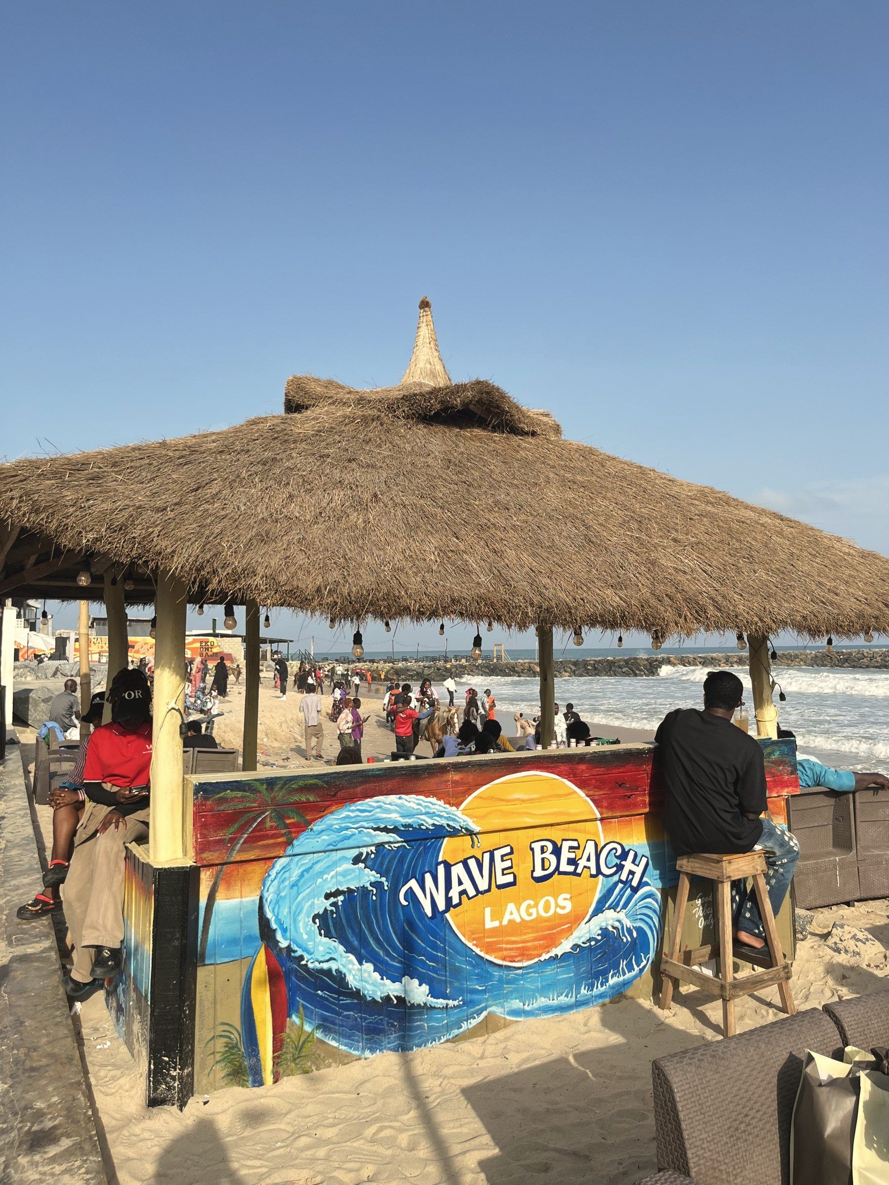 The thatched beach hut with the Wave Beach Lagos mural, by the sea