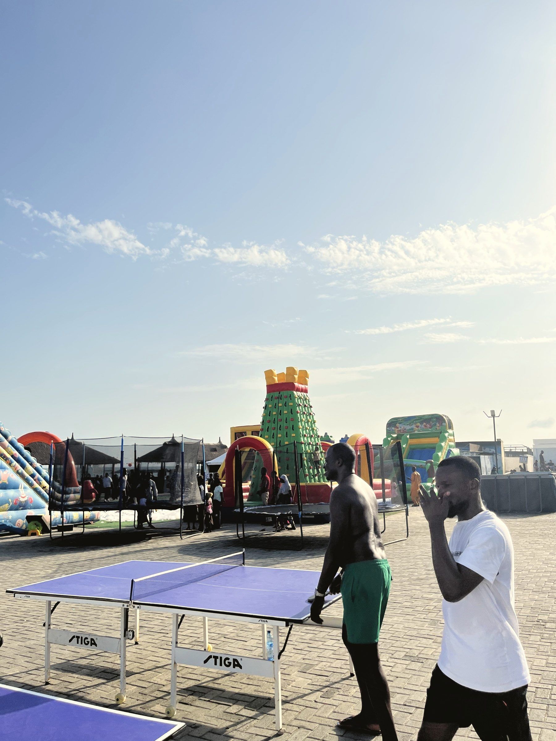 Guests playing table tennis beside the bouncing castles