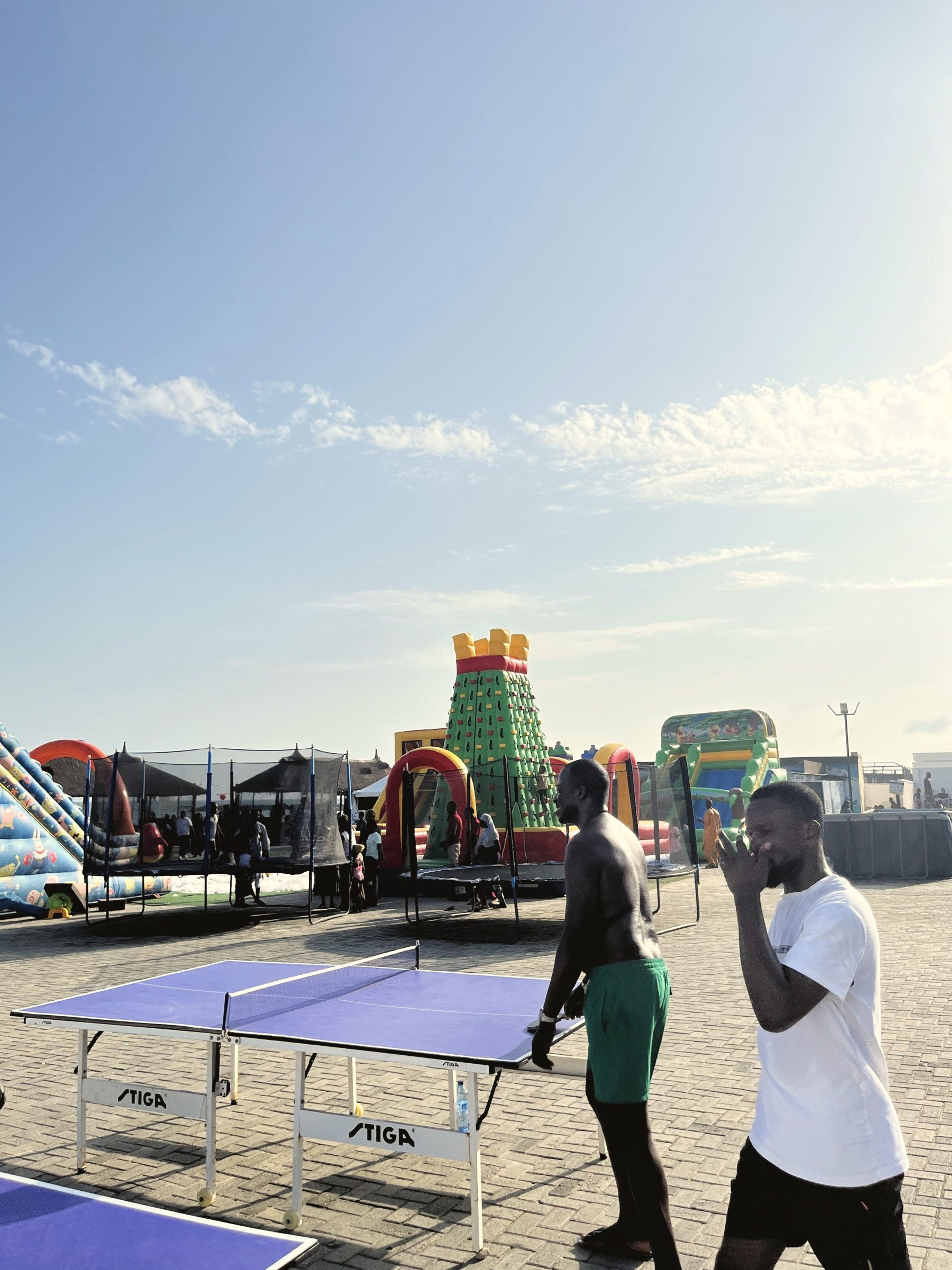 Guests playing table tennis beside the bouncing castles