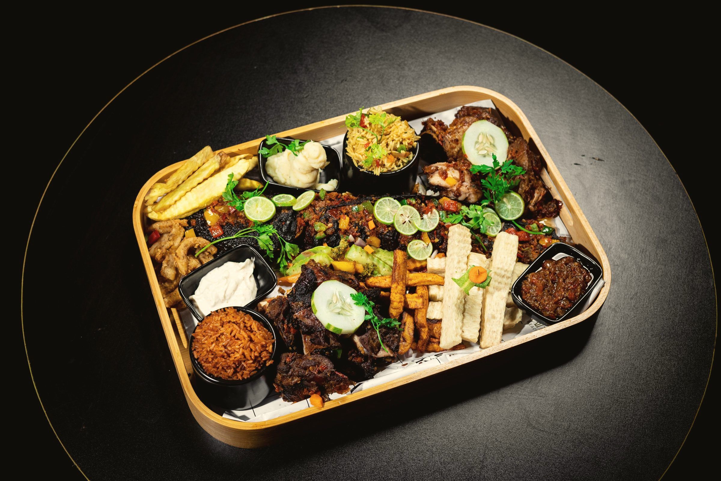 A sharing platter of grills, jollof rice, fries and dips