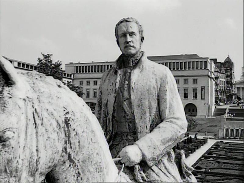 Schwarz-Weiß-Fotografie einer Steinstatue. Die Statue zeigt einen Mann in einem langen Mantel auf einem Pferd