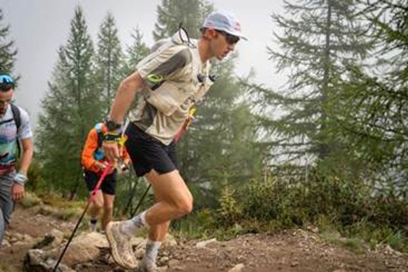 Tom Evans, vainqueur de l’UTMB 2025 participe à un trail dans une fôret de pin.
