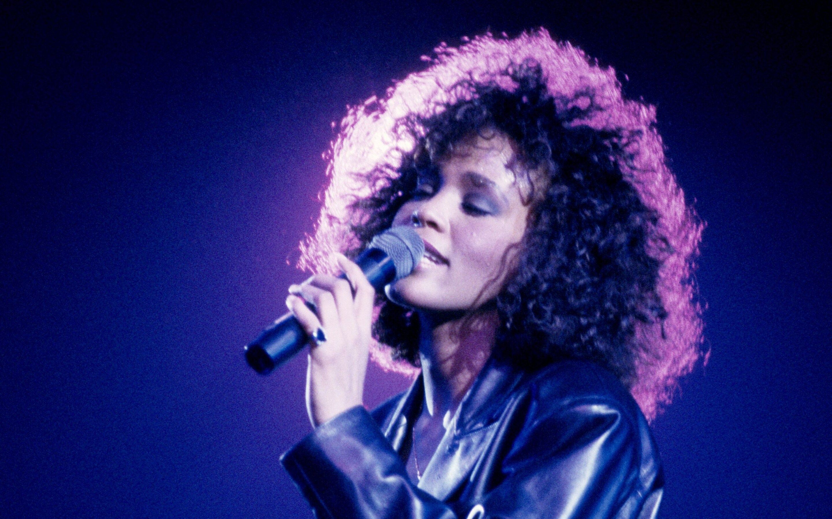 Whitney Houston singing into a microphone