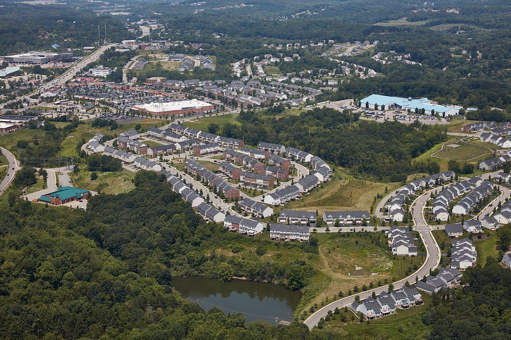 This is an aerial view capturing a suburban landscape characterized by a mix of residential and commercial development.