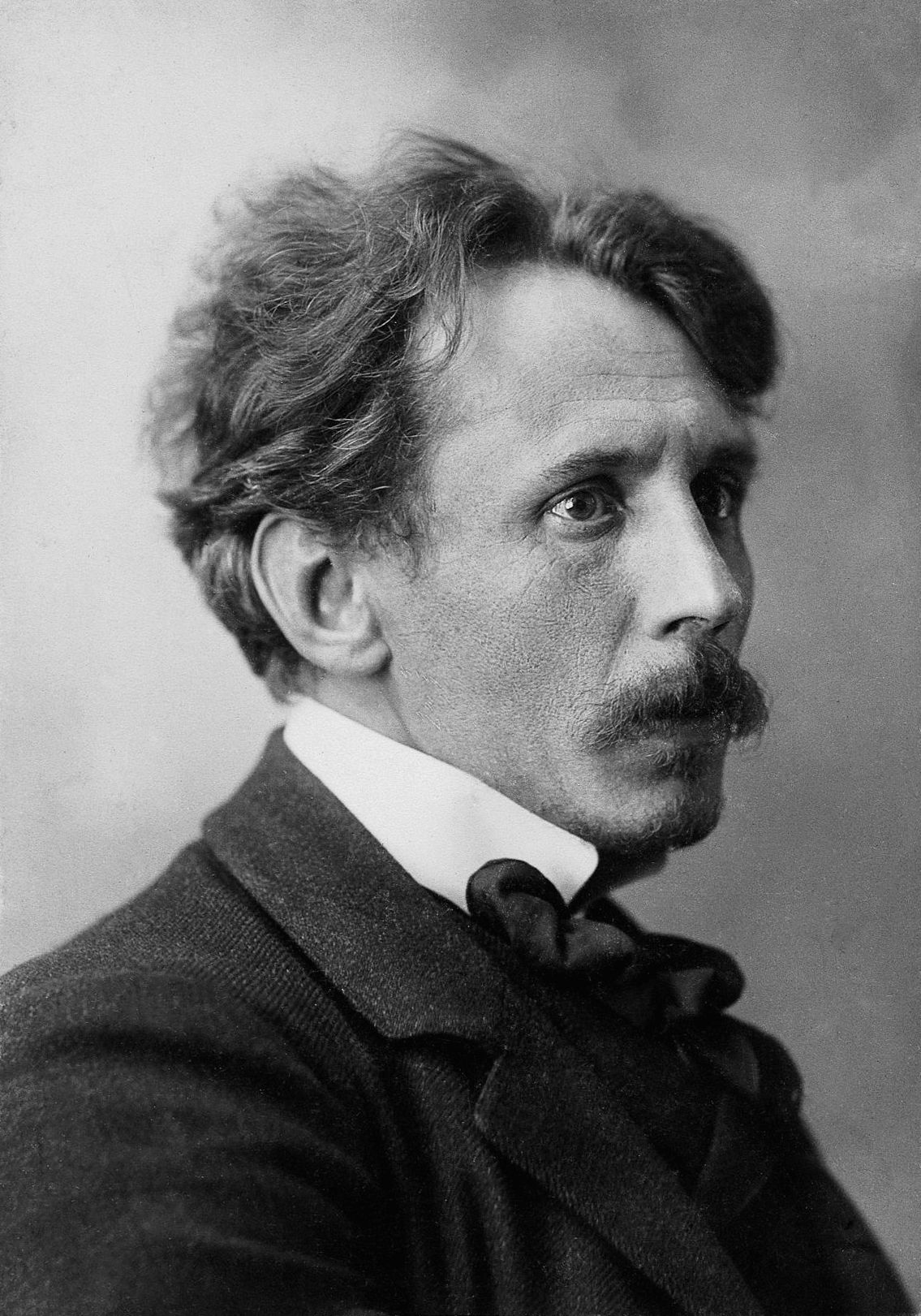 Black-and-white archival portrait photo of Čiurlionis, a man in early 20th-century dress