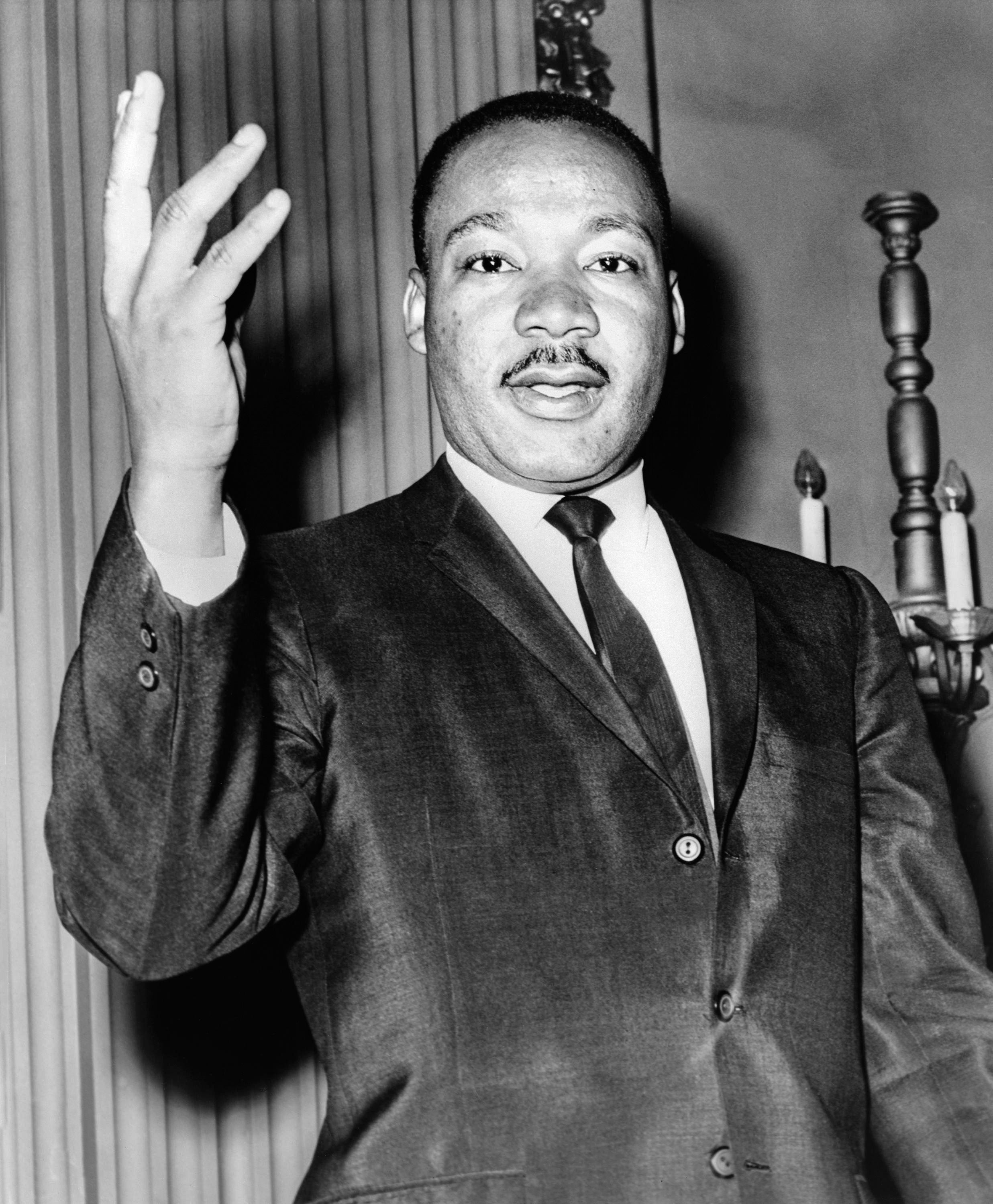 Black and white portrait photo of Martin Luther King Jr. wearing a suit and tie