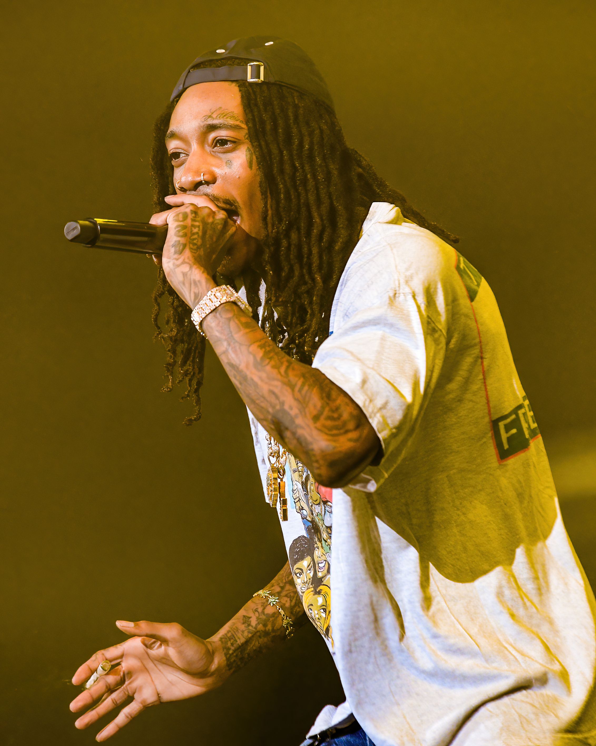 Wiz Khalifa performing on stage at an outdoor amphitheater, 2023