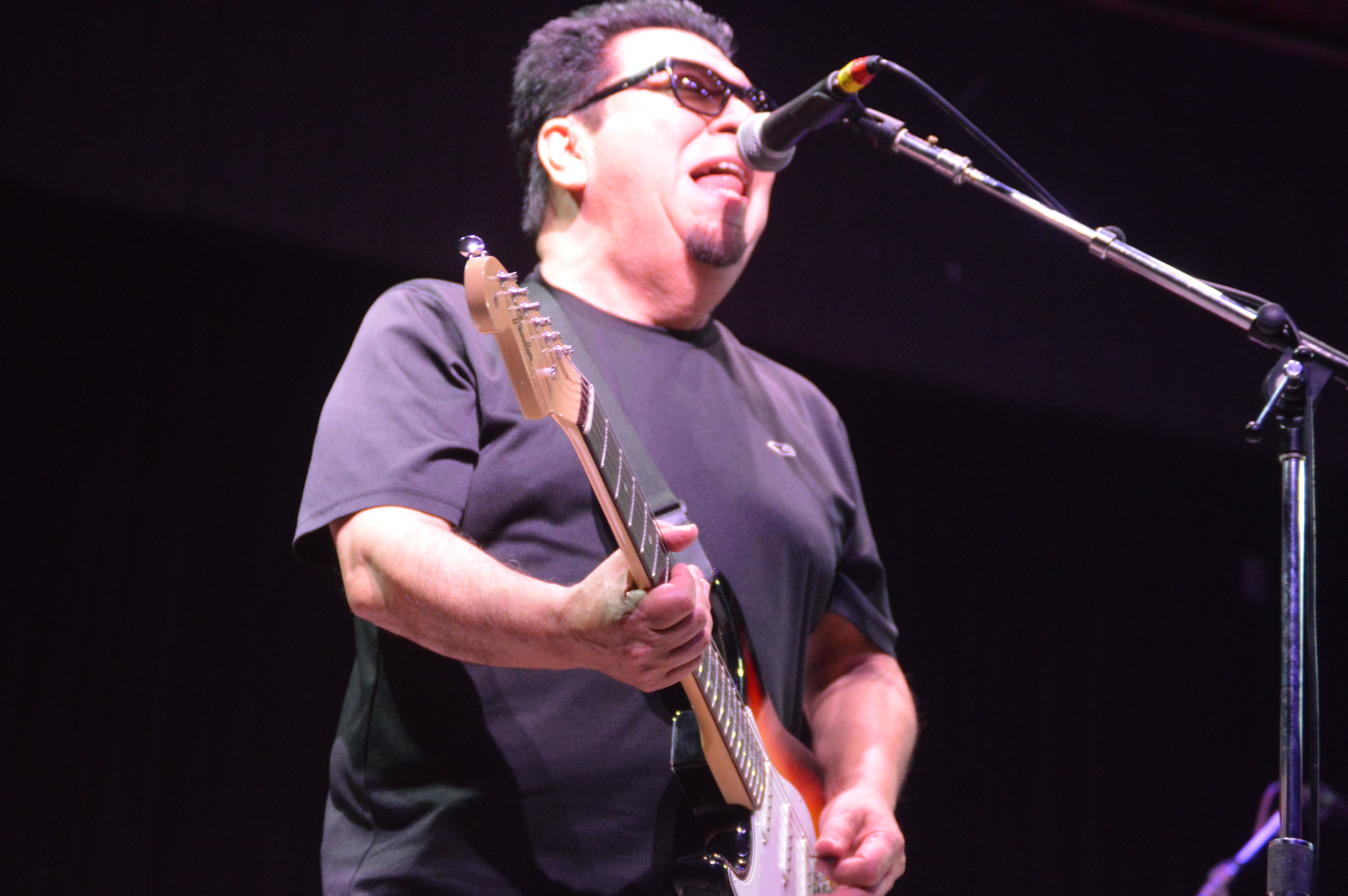 Members of the band Los Lobos performing on stage at a folk festival
