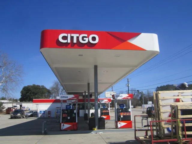 Citgo canopy with a red fascia over the dispensers, crates of materials stacked beside the islands