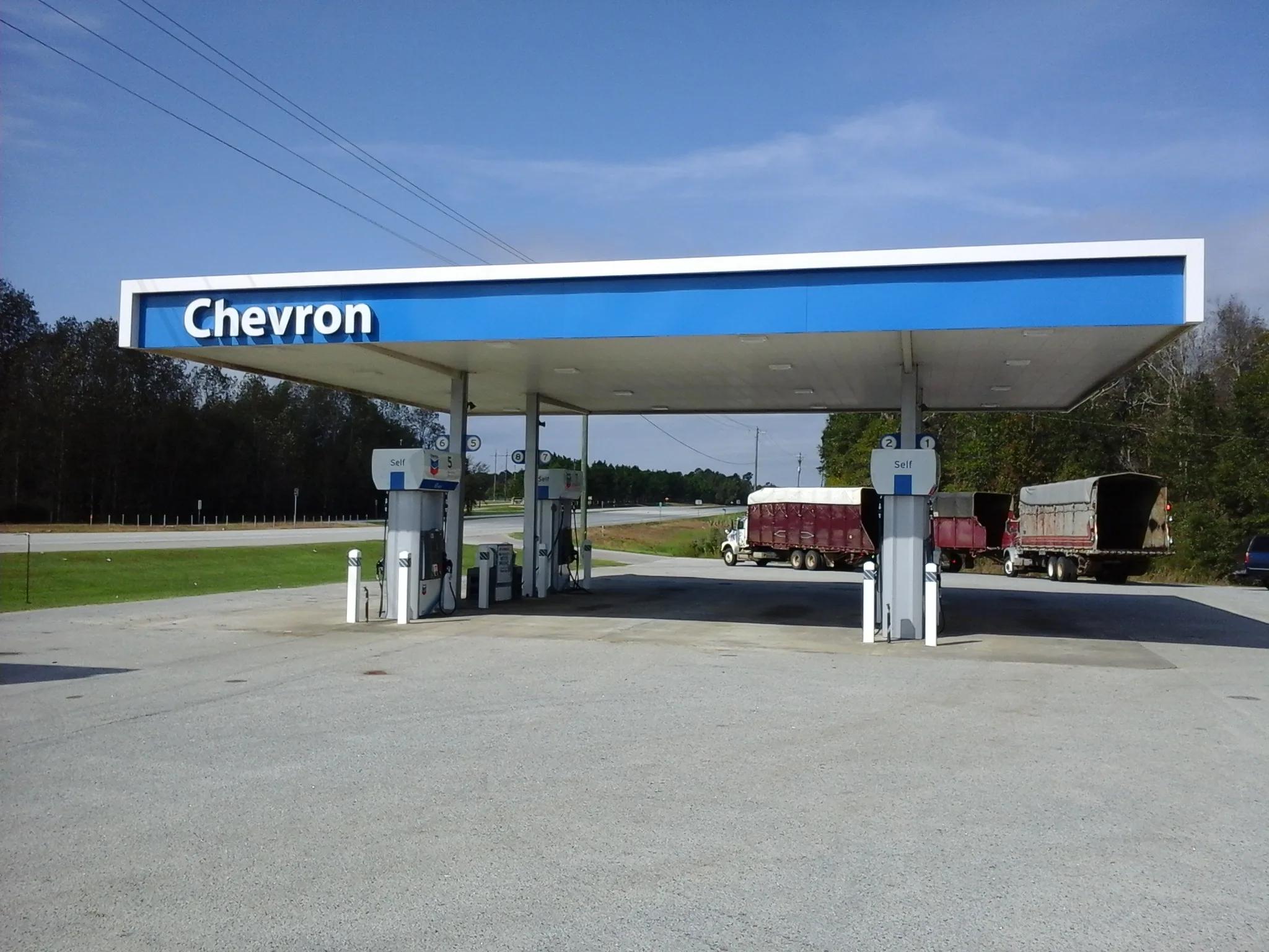 Chevron canopy with a blue fascia over diesel dispensers, trucks parked beyond
