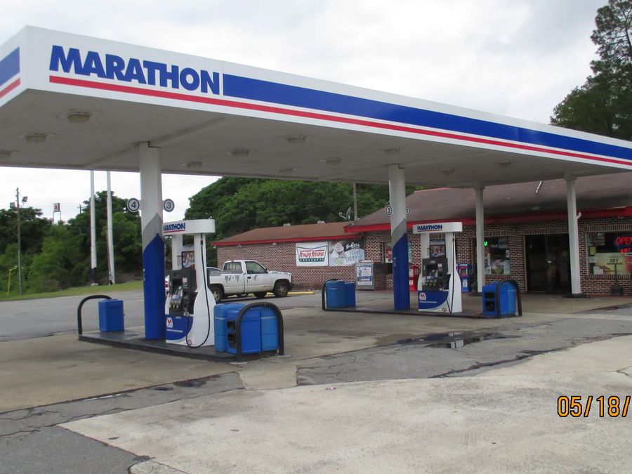 Marathon canopy with a blue and red striped fascia over dispensers, a store behind