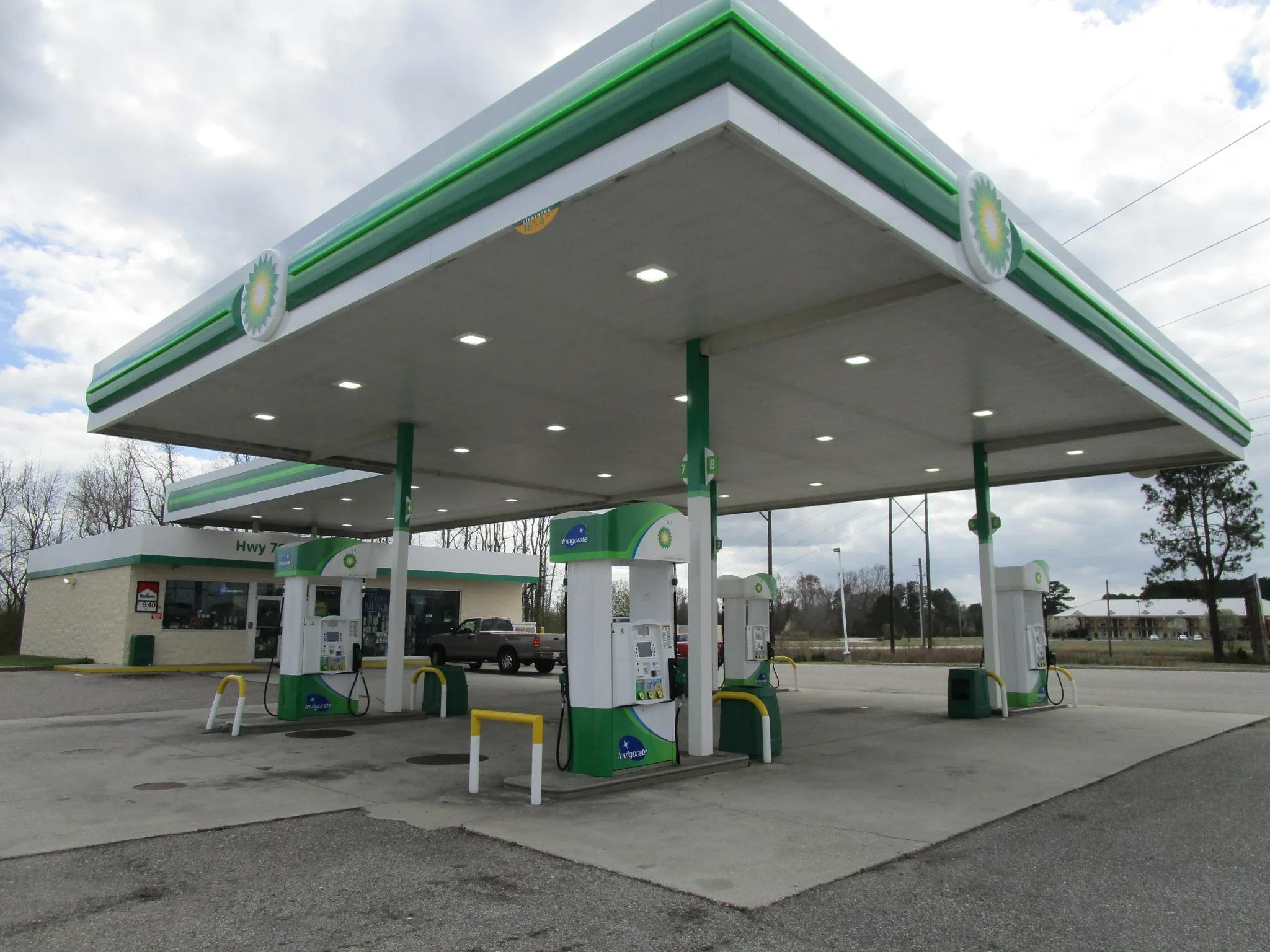 BP canopy with a green and white fascia over dispensers in front of a small store