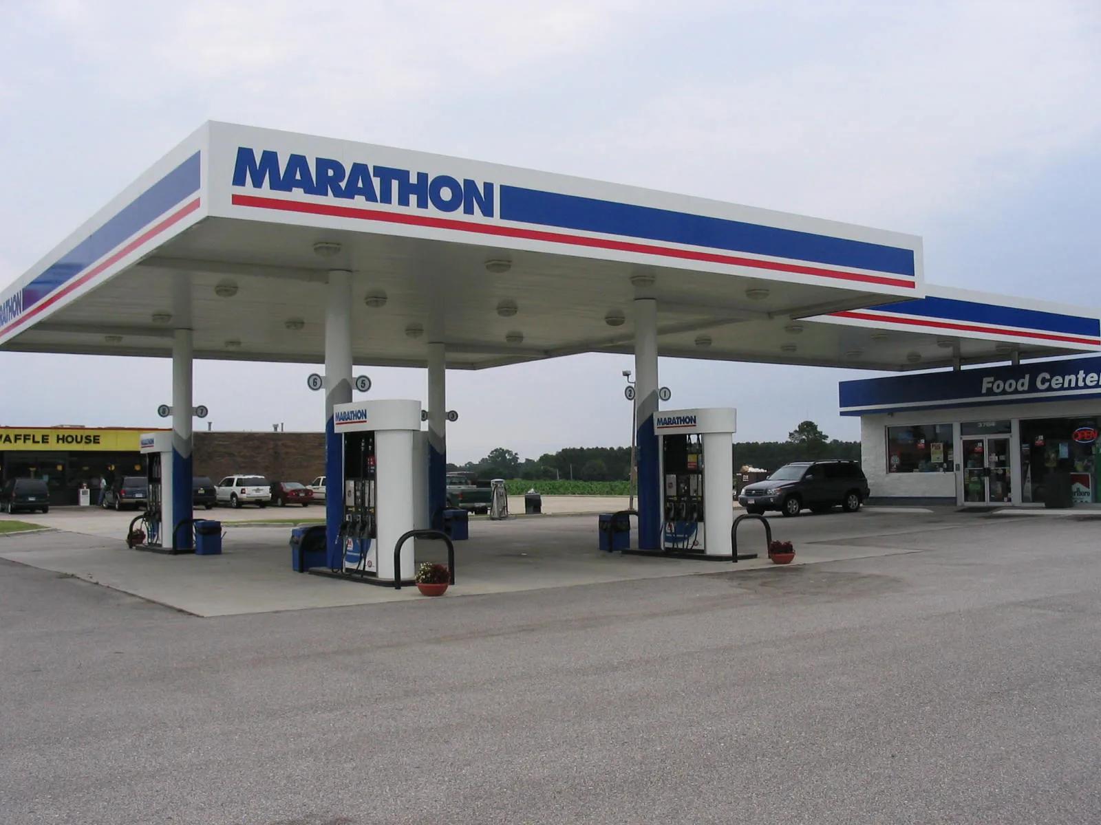 Marathon canopy with a blue and red fascia over dispensers next to a store