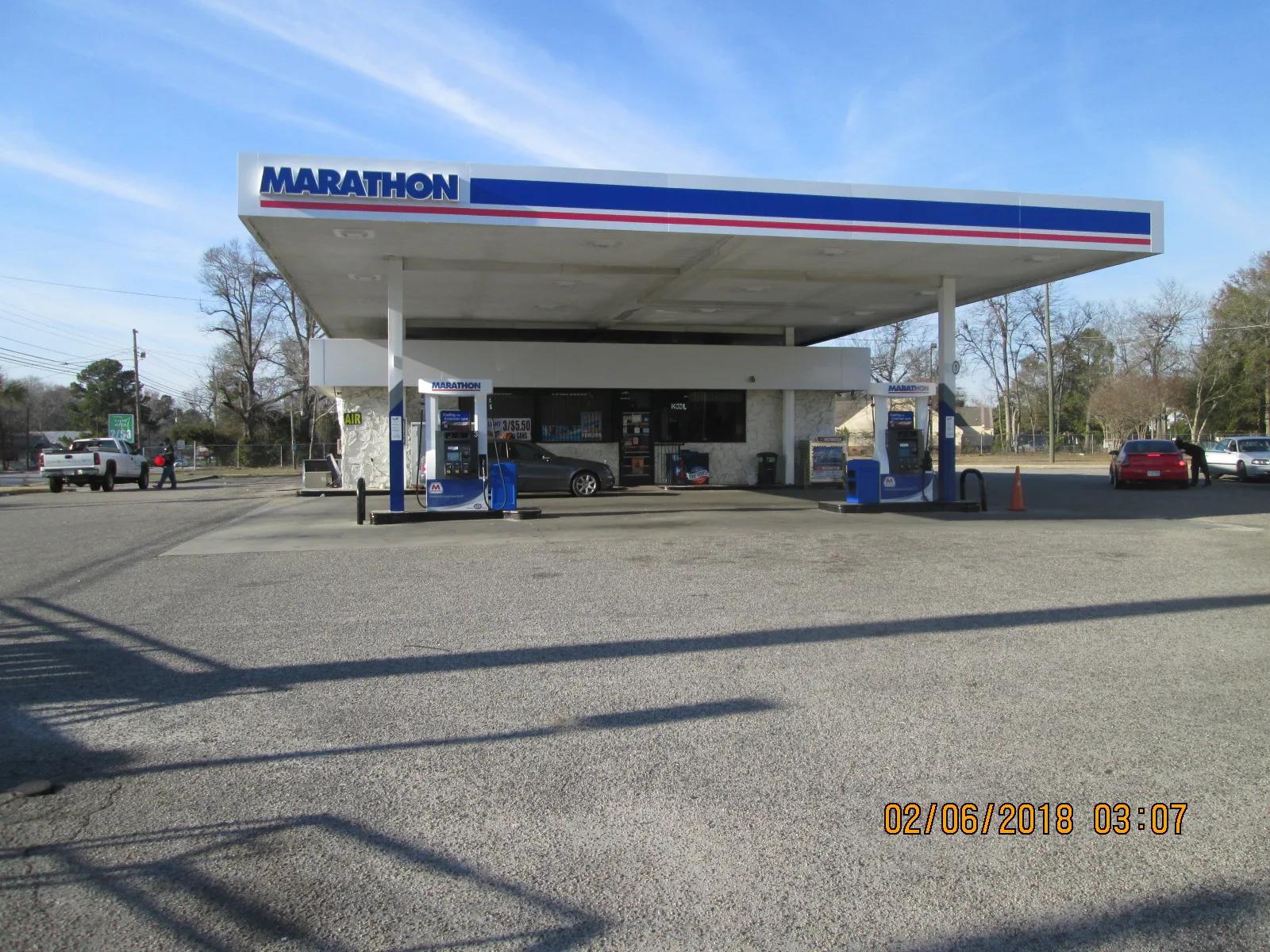 Marathon canopy with blue and red stripes over two dispensers in front of a store
