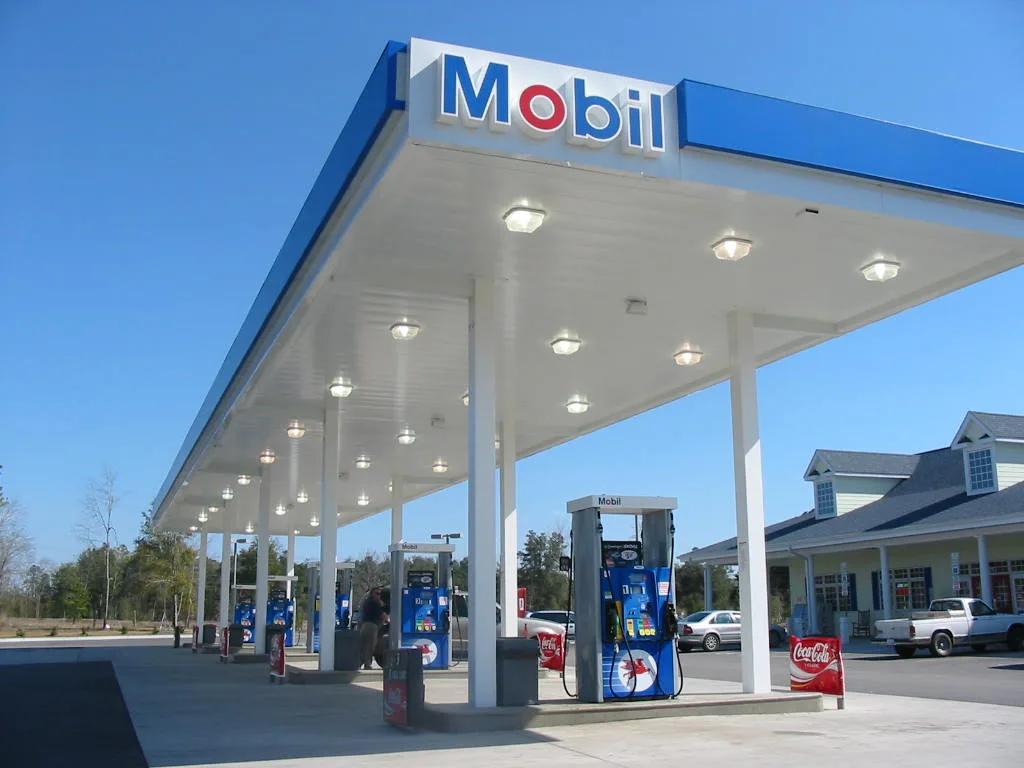 Mobil canopy with a blue fascia and Mobil sign, rows of recessed lights over the dispensers