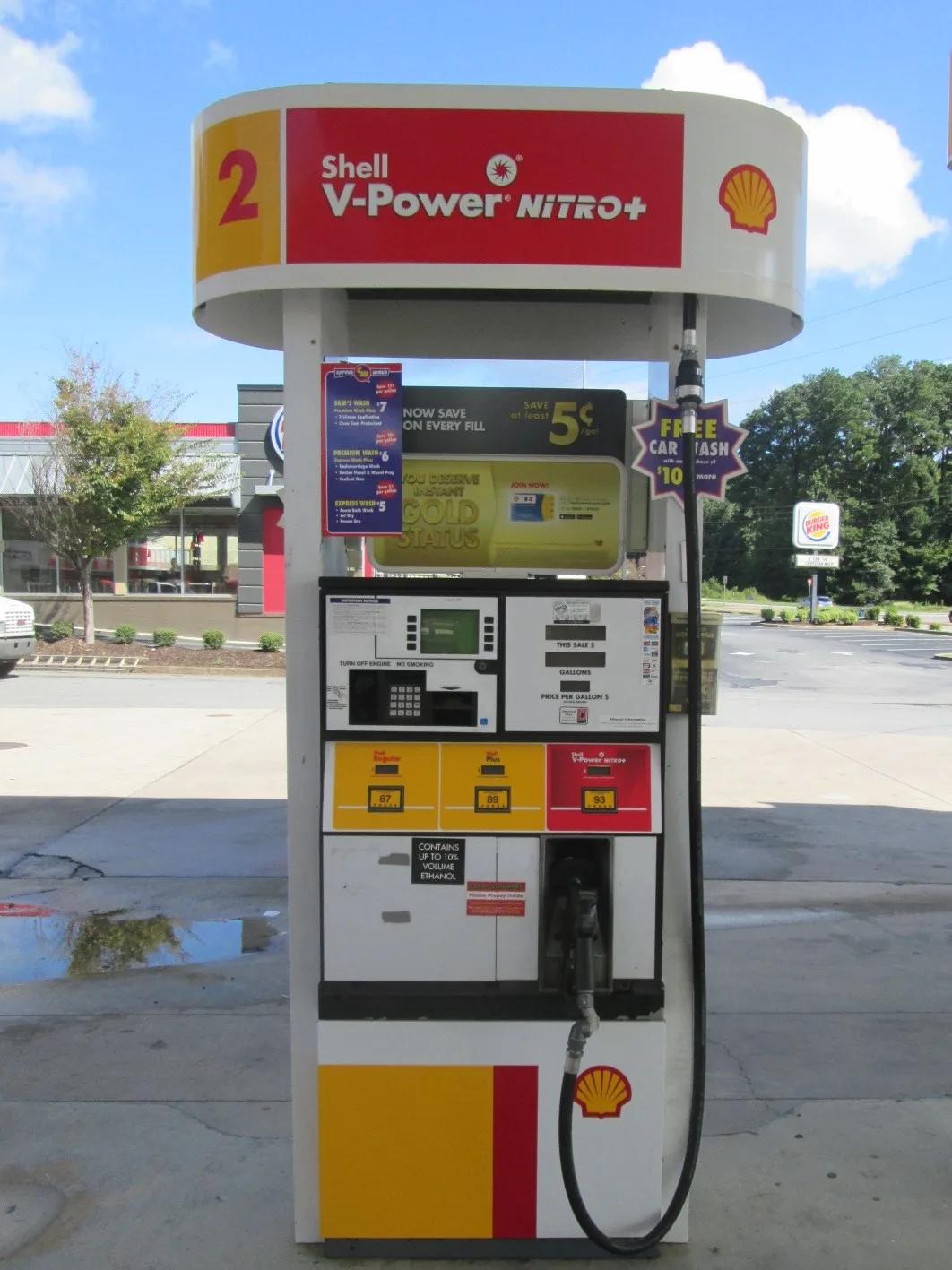 Shell dispenser with a red and yellow V-Power topper sign