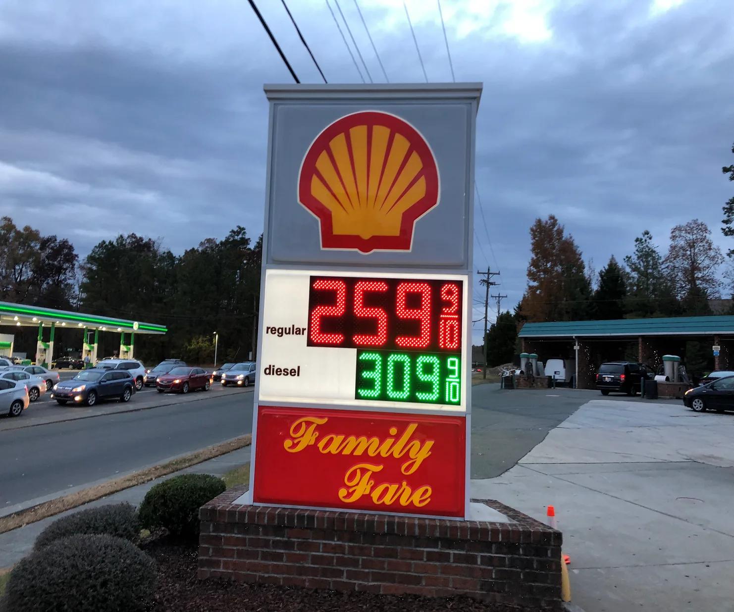 Shell monument price sign at dusk with red and green LED price numerals