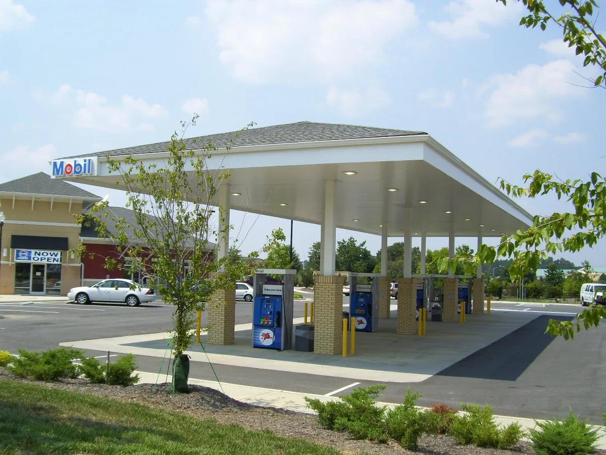 Hip-roof canopy on brick columns over Mobil dispensers, new landscaping in front