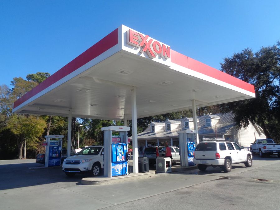 Exxon canopy with a red and white fascia and a lit Exxon sign over blue dispensers