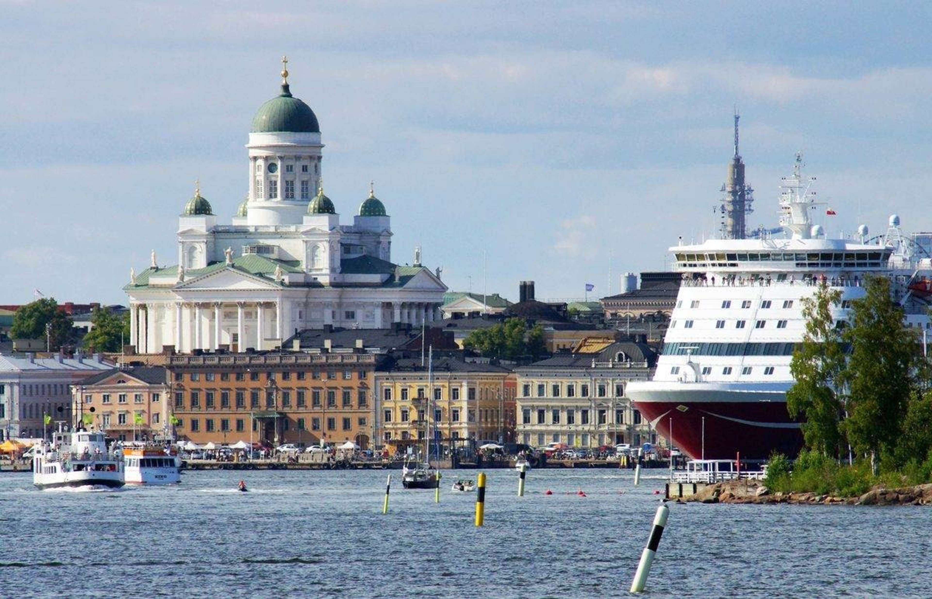 Helsingin tuomiokirkko ja suuri matkustajalaiva Eteläsatamassa kesäpäivänä