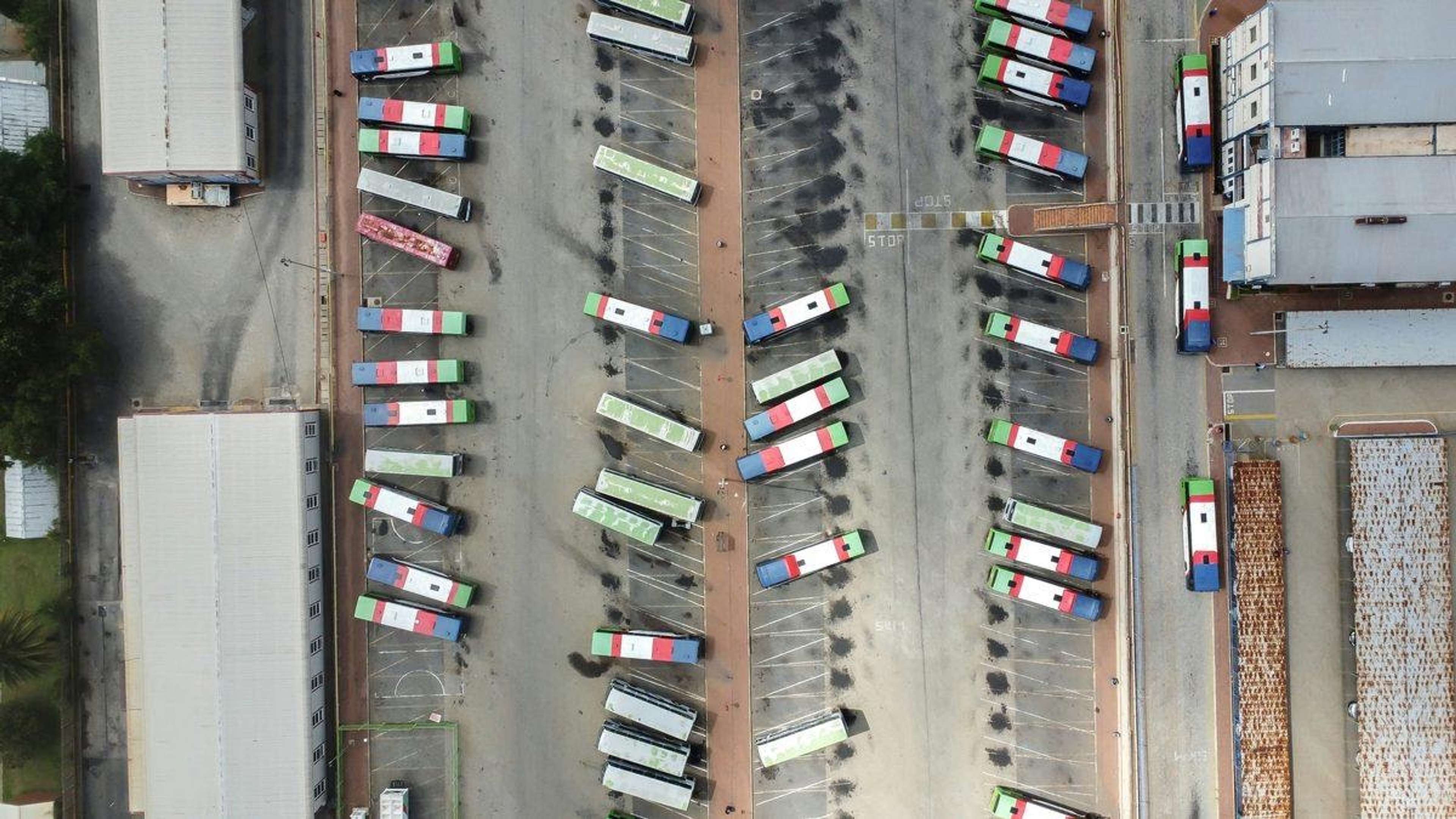 Luftfoto af et busdepot med mange busser parkeret i rækker