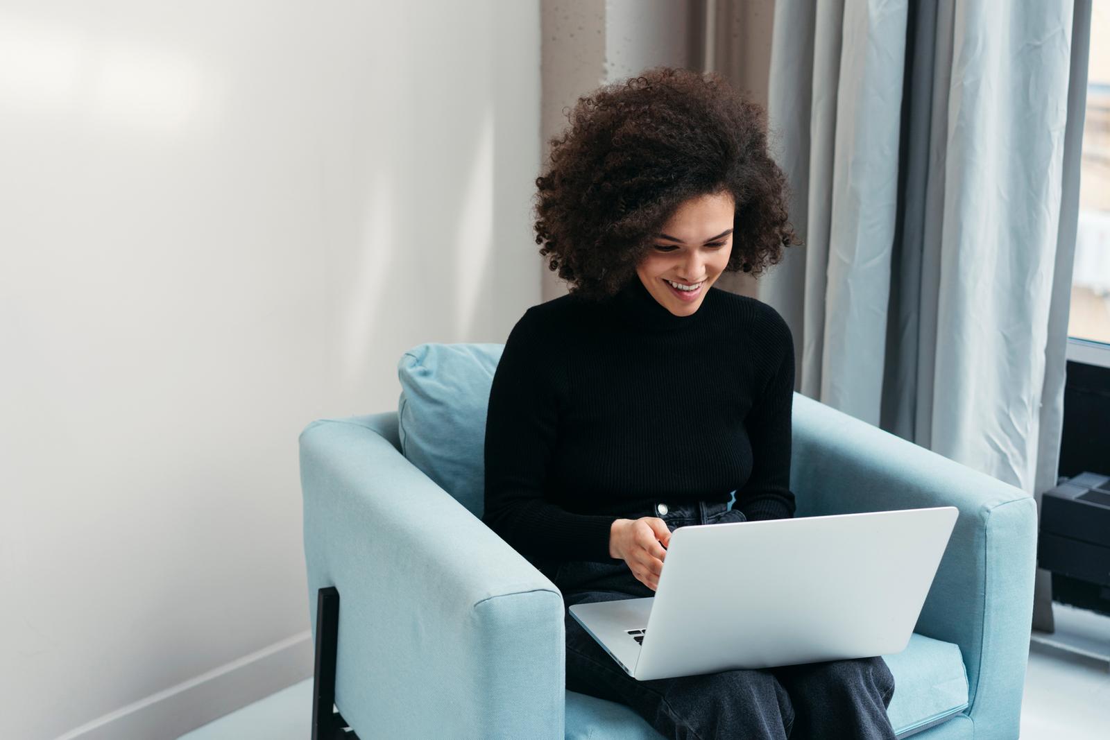 Woman smiling while looking at laptop