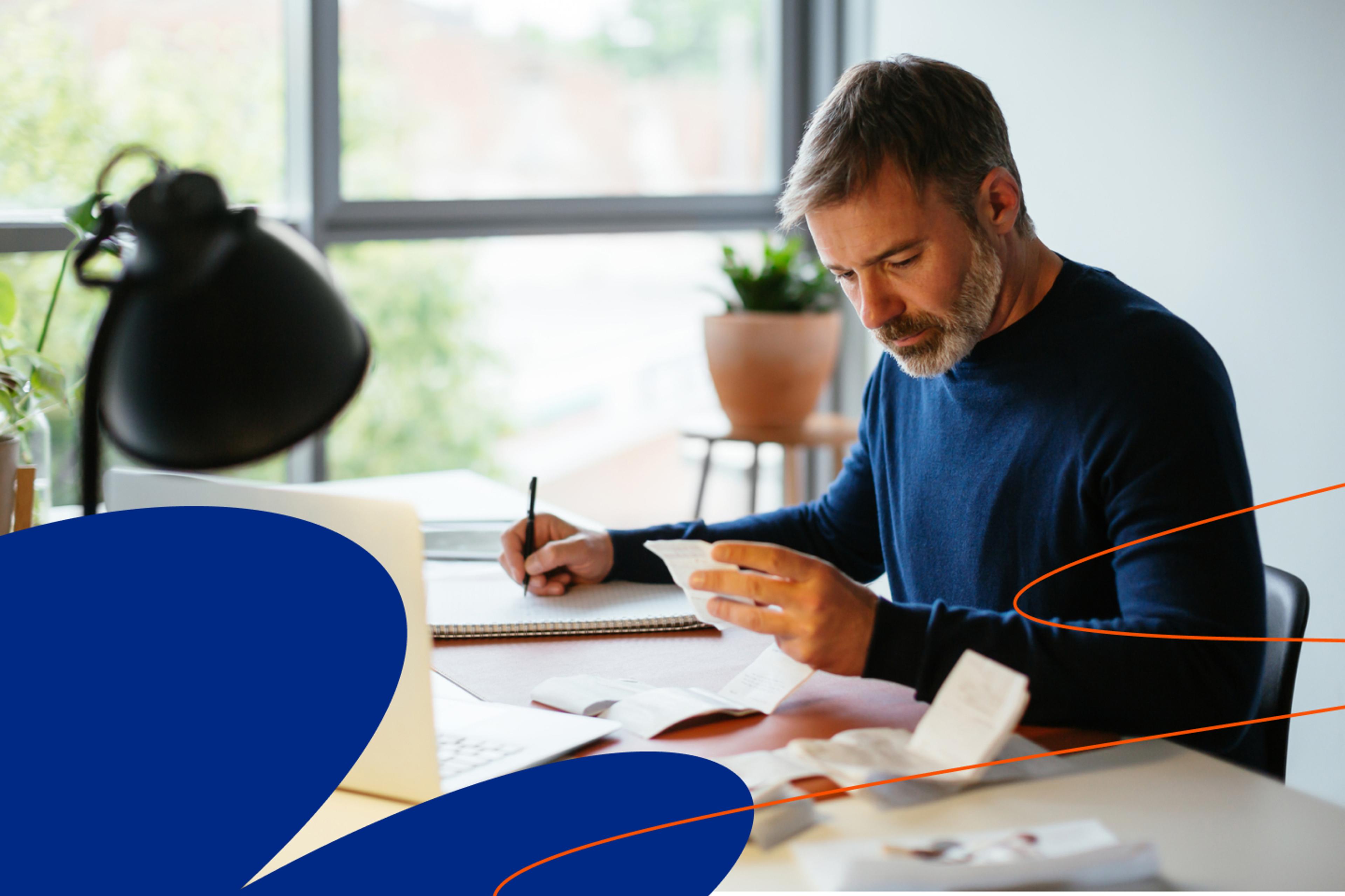 Person at desk looking at paper and writing