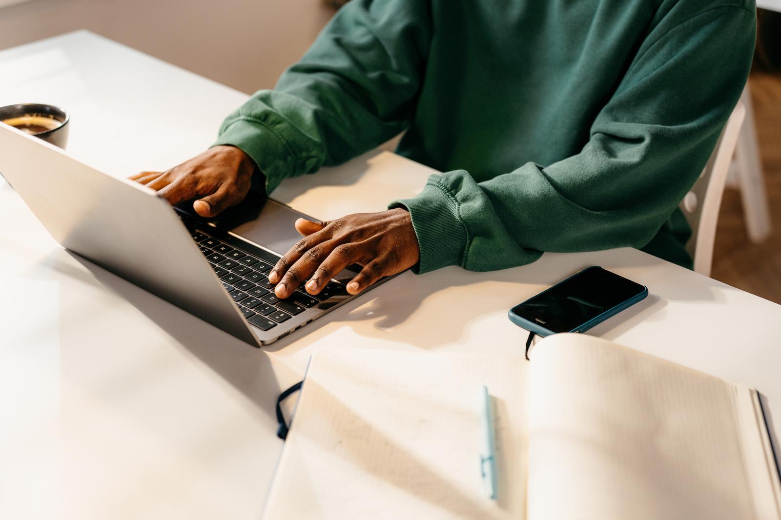 Hands typing on laptop