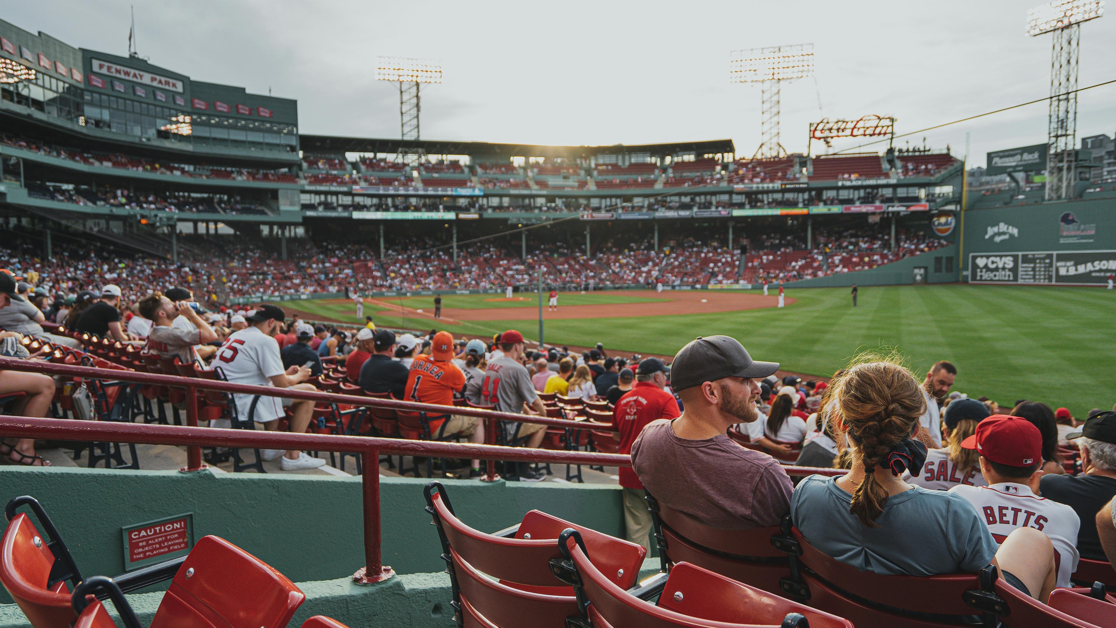 fans sit in the stands at the Boston Red Sox baseball stadium