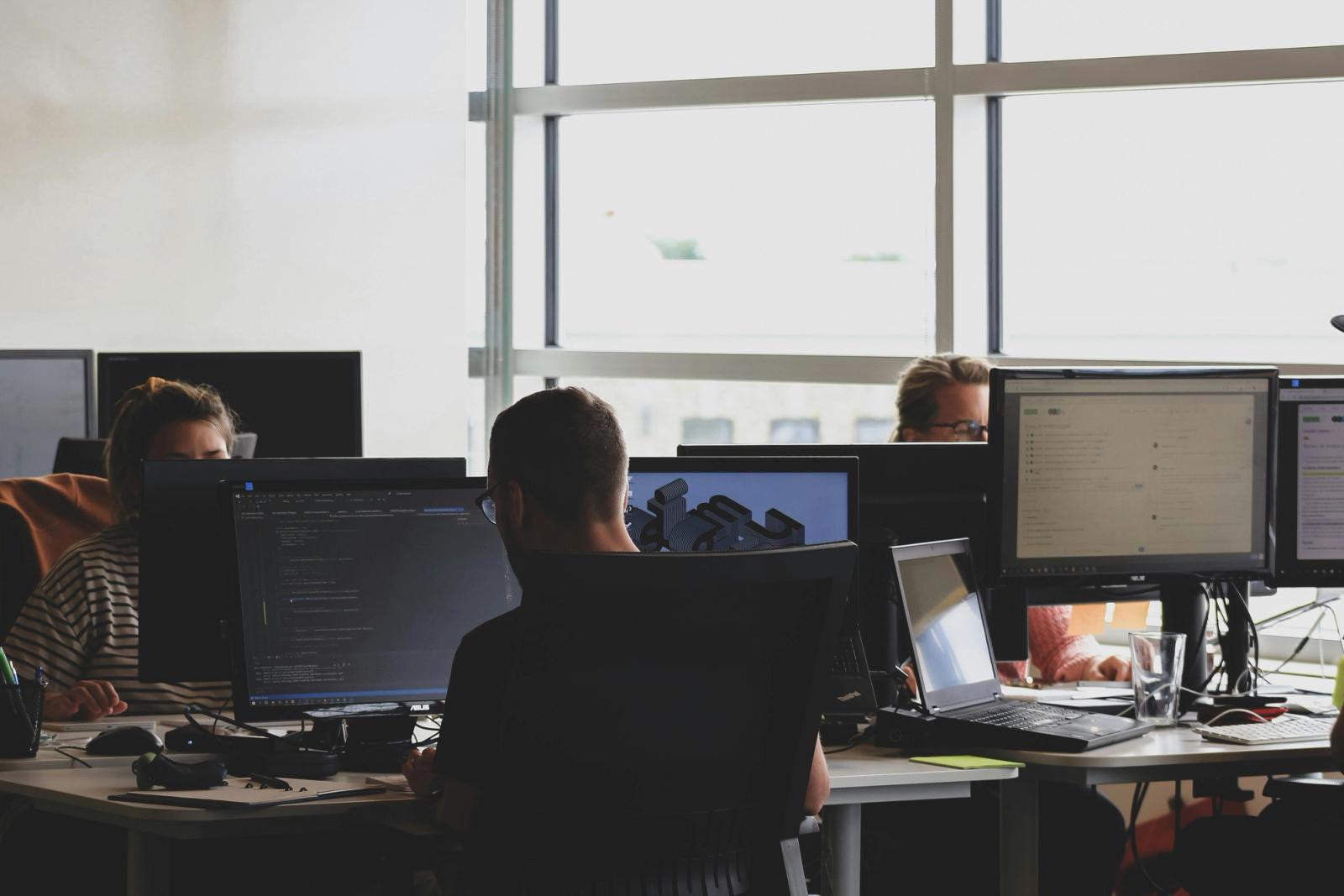 People sitting at desks and working on computers in an office