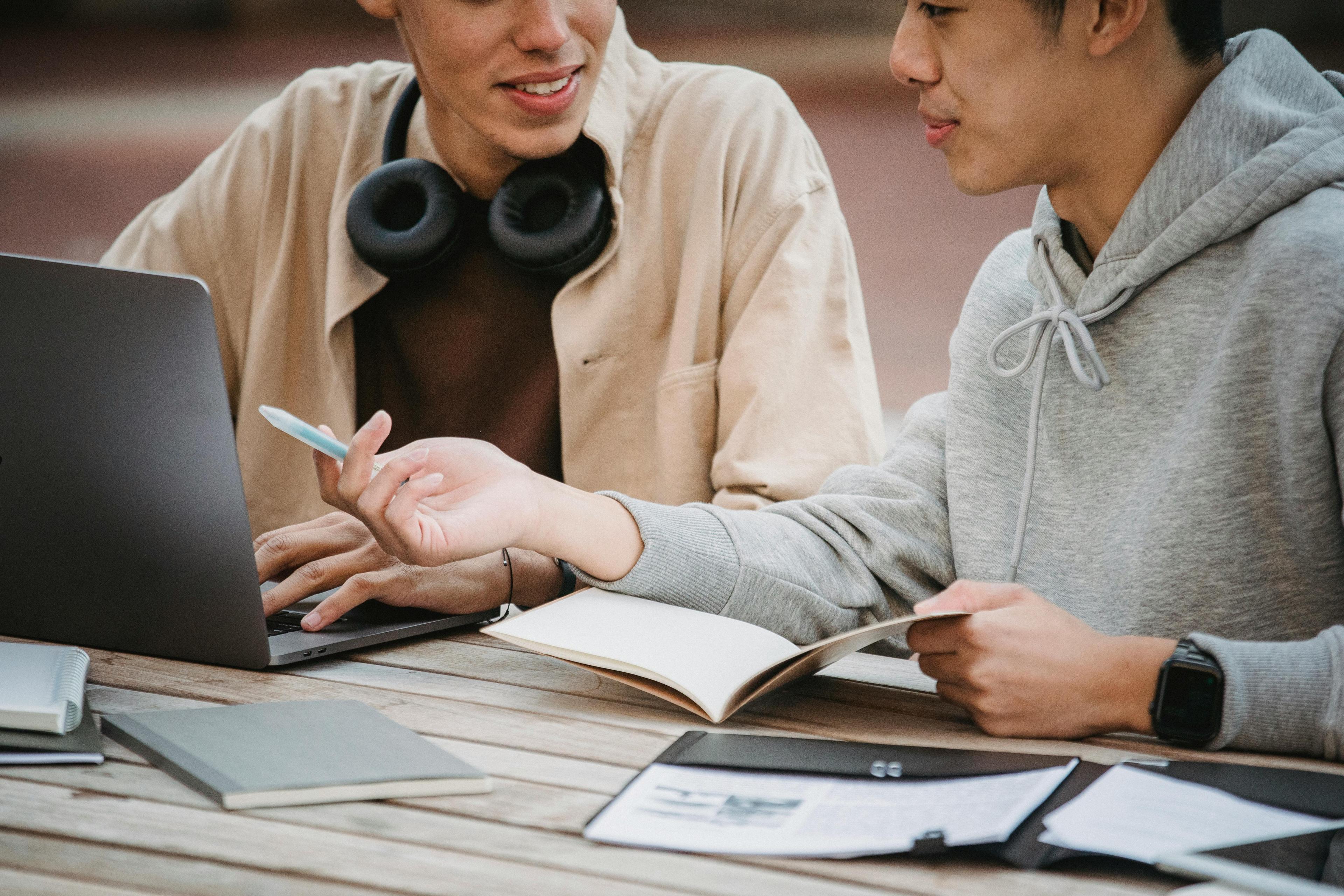 two students with laptop on campus