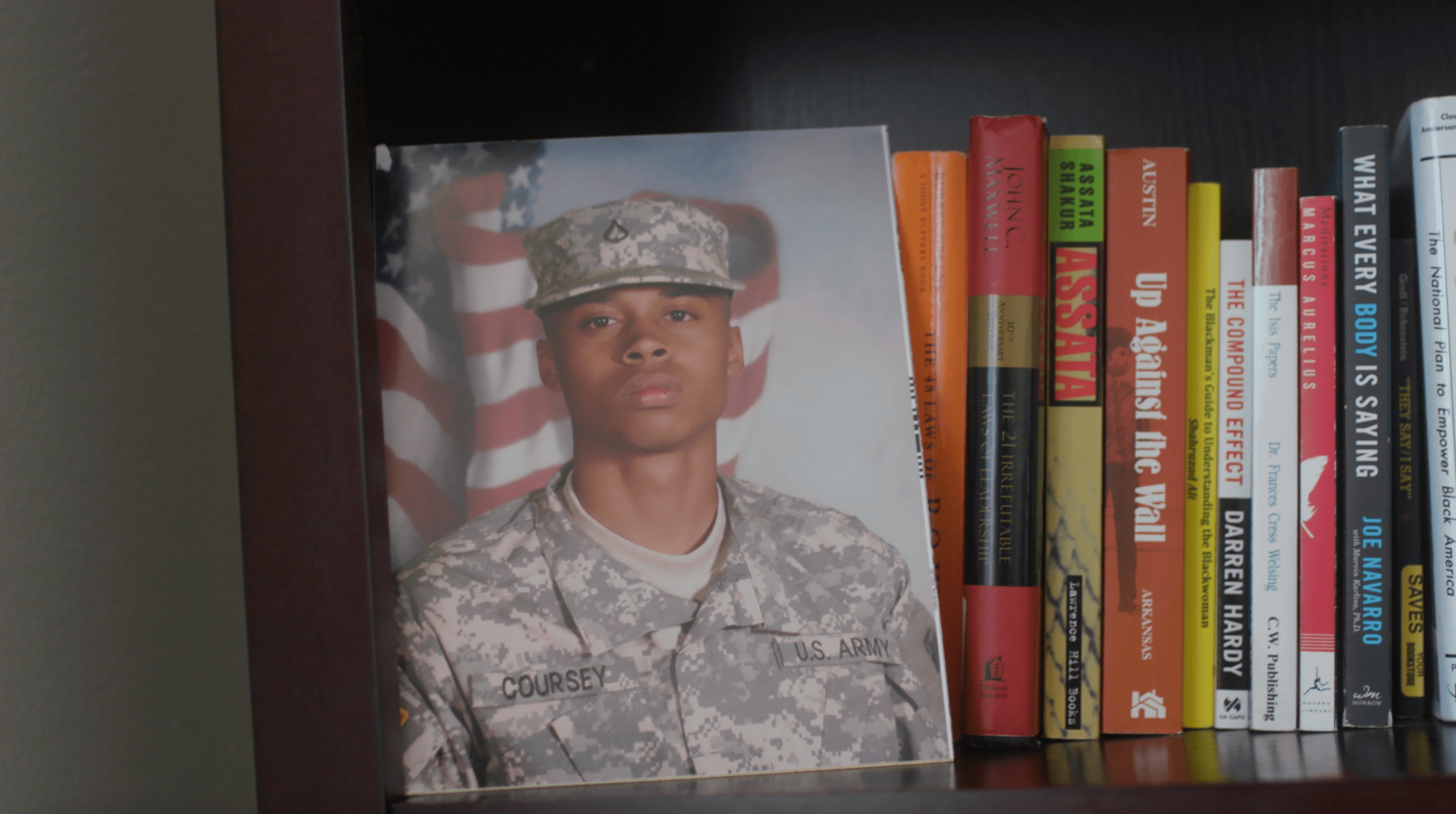 Veteran displays Army portrait on a bookshelf in his home