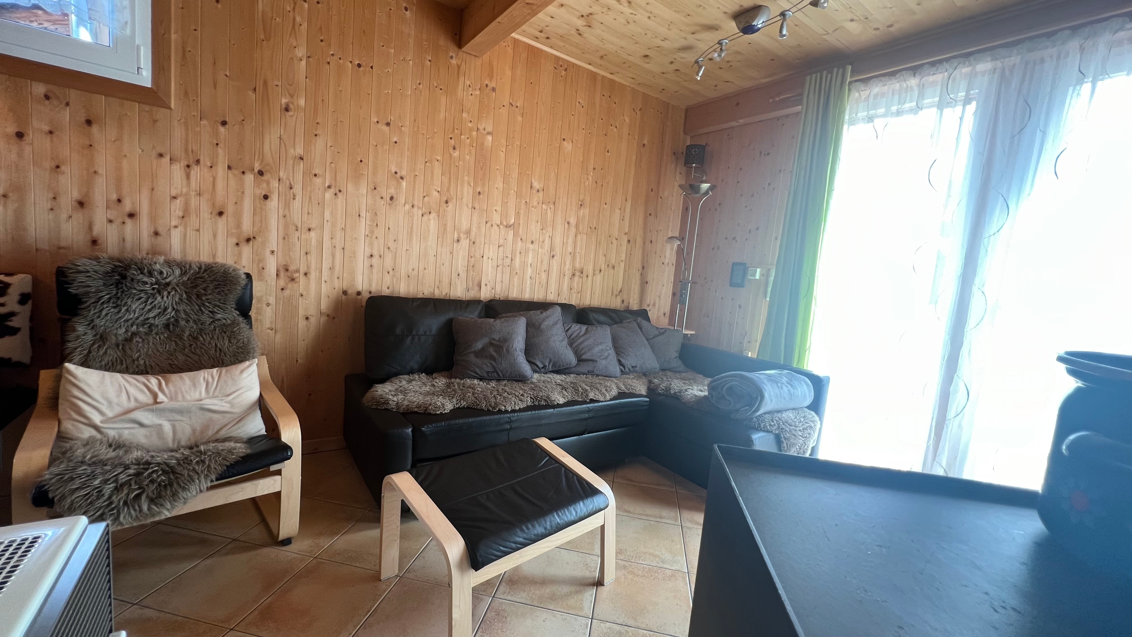 Wohnzimmer mit bequemen Sofa und Sessel zum entspannen nach einem anstrengenden Skitag