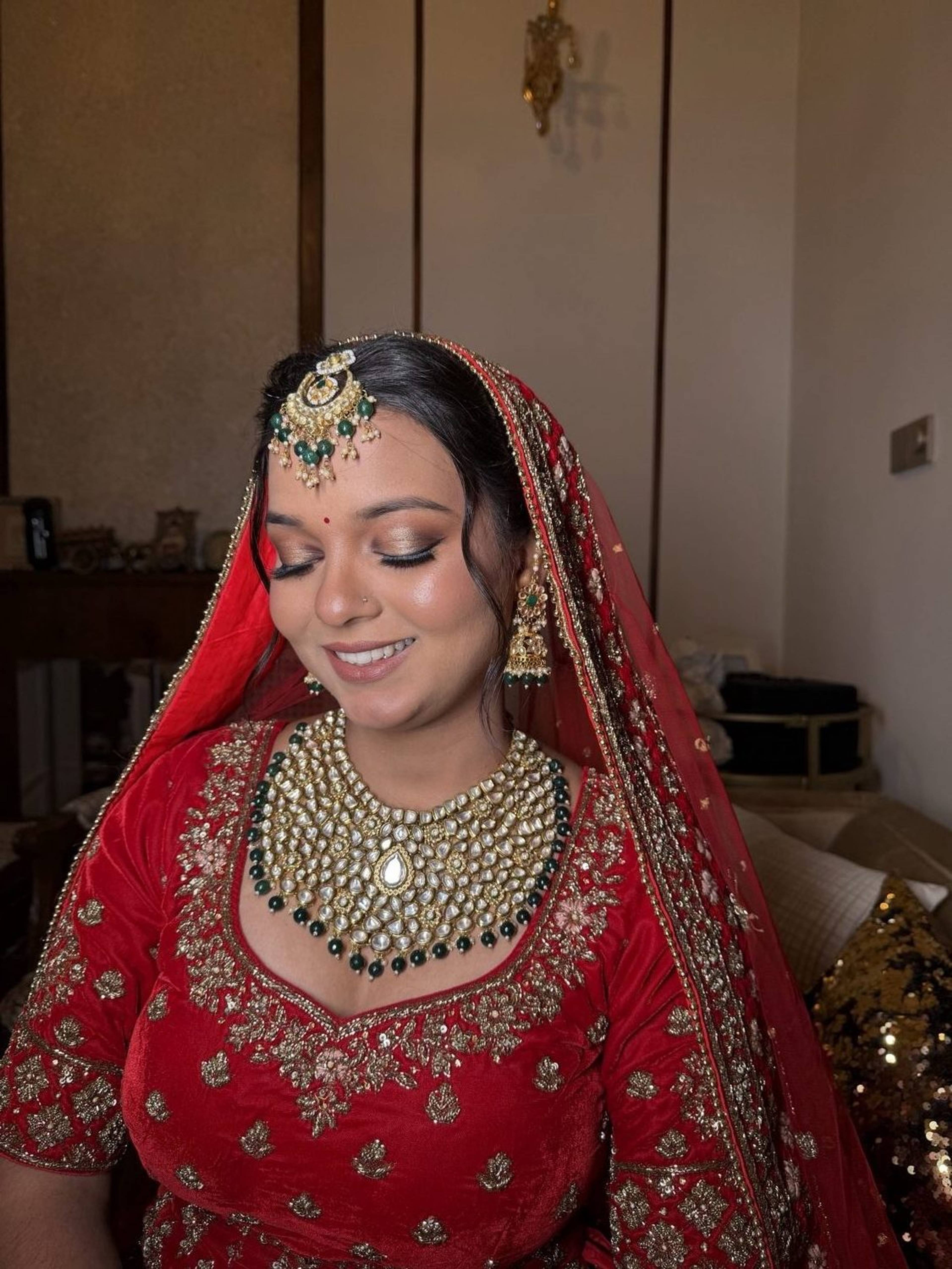 Bride in a red lehenga with kundan jewellery and soft smokey bridal eye makeup by Priya Maleri, Tricity