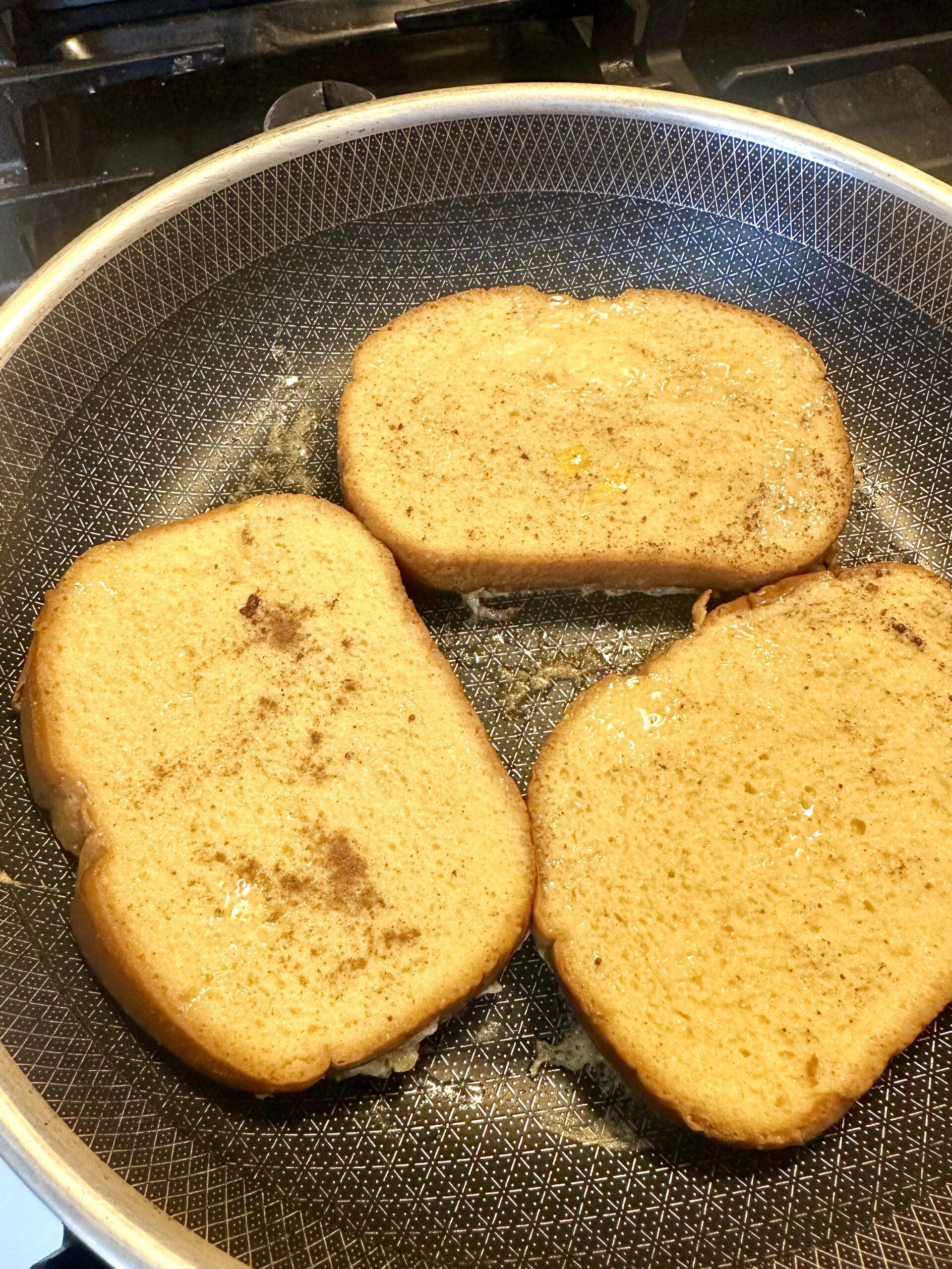 Golden slices of French toast finishing in the skillet