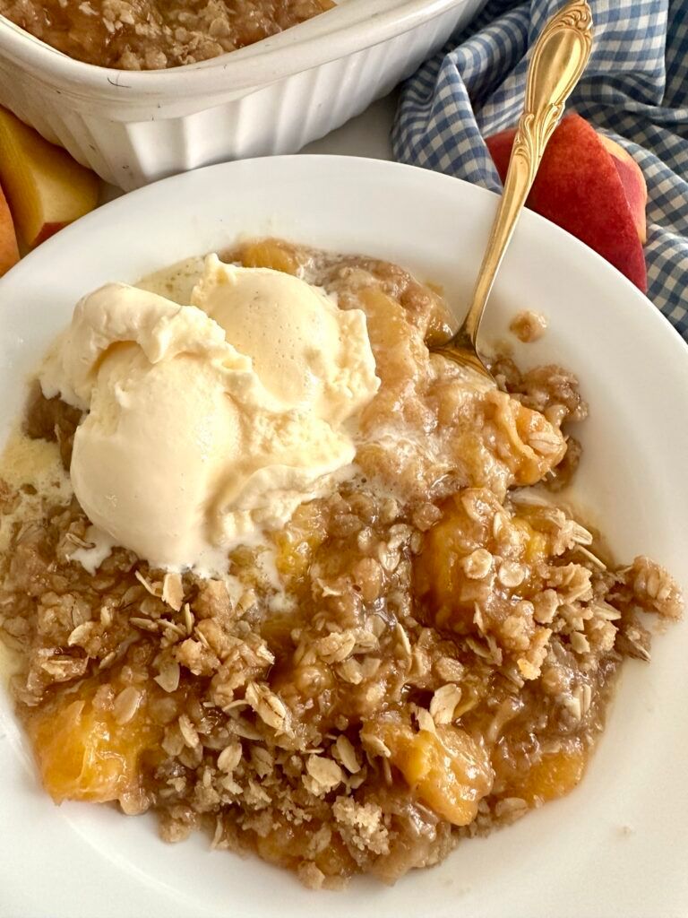 Warm peach crisp topped with vanilla ice cream