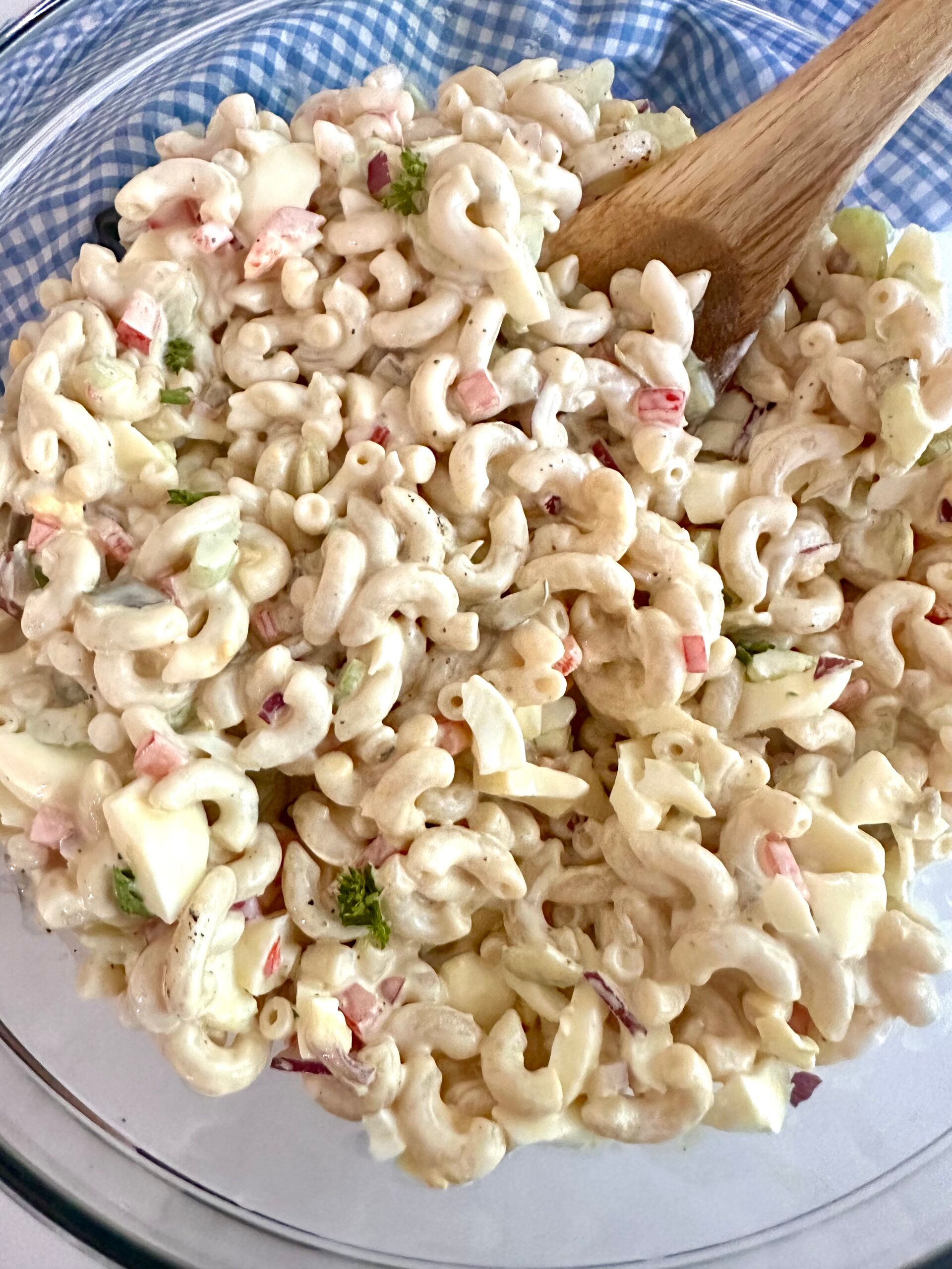 Macaroni salad mixed together in a large glass bowl