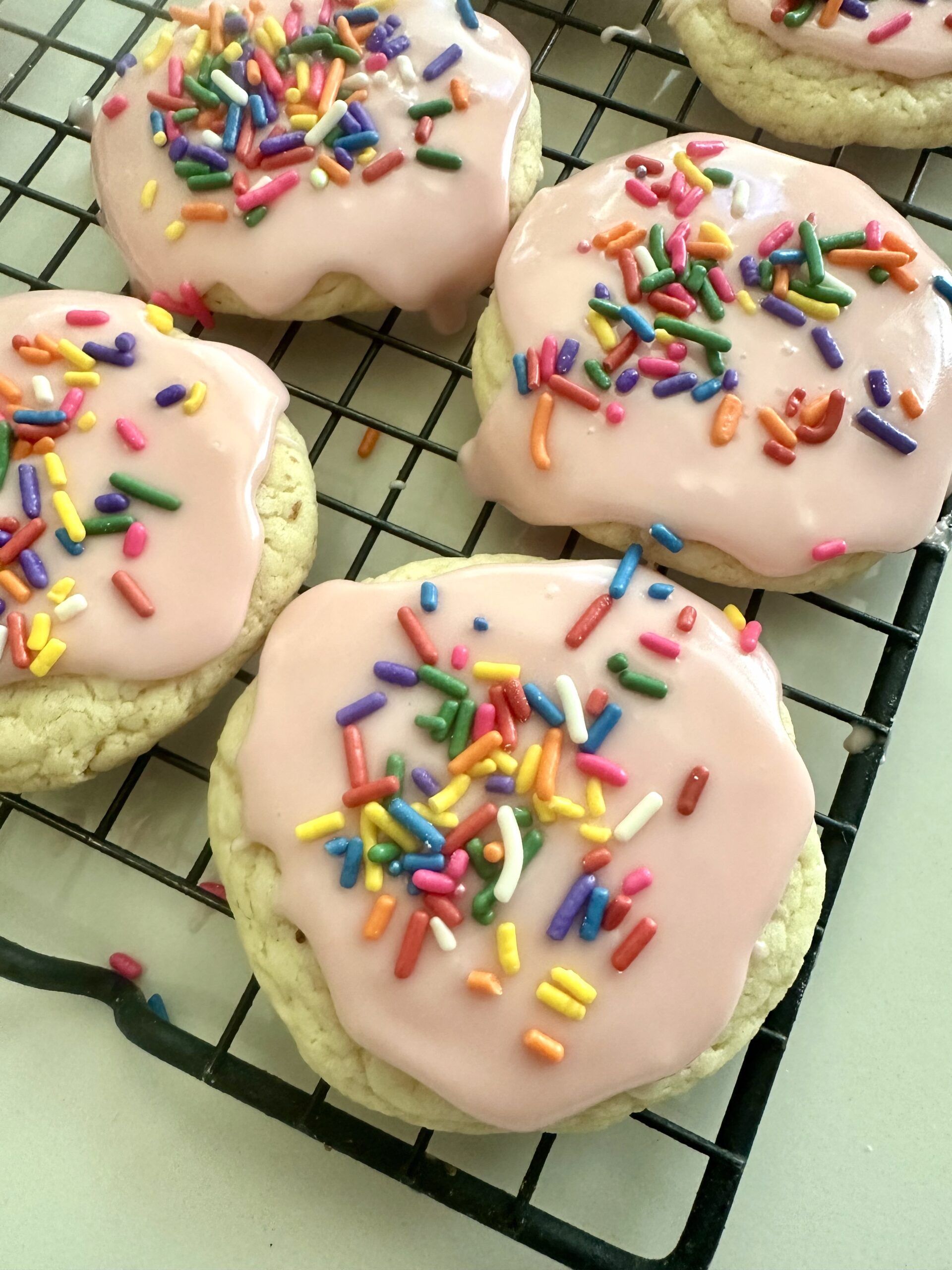 Vanilla glaze being drizzled over cooled cake mix cookies