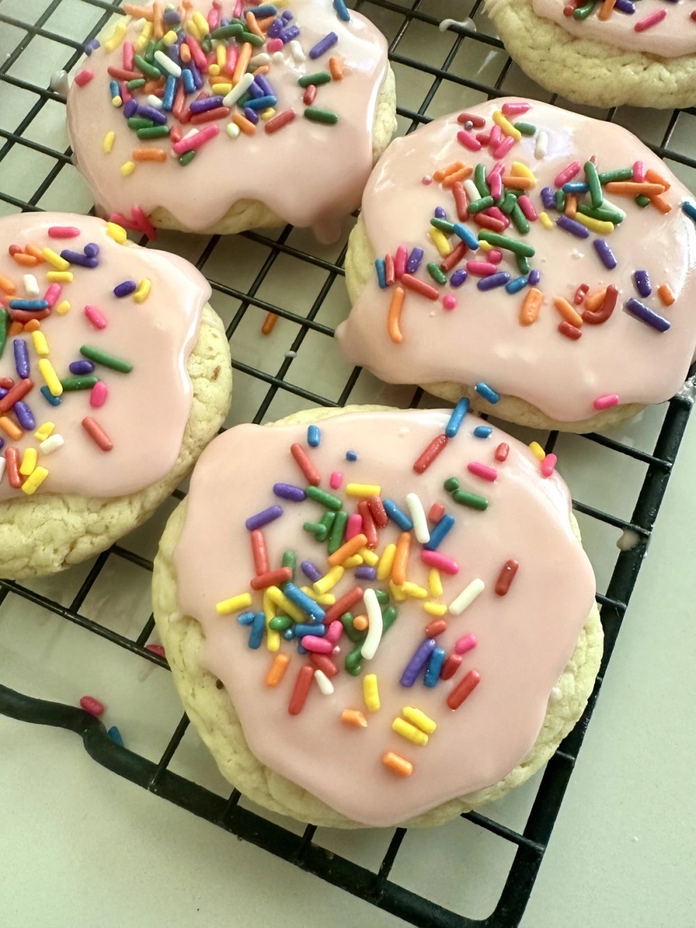 Vanilla glaze being drizzled over cooled cake mix cookies
