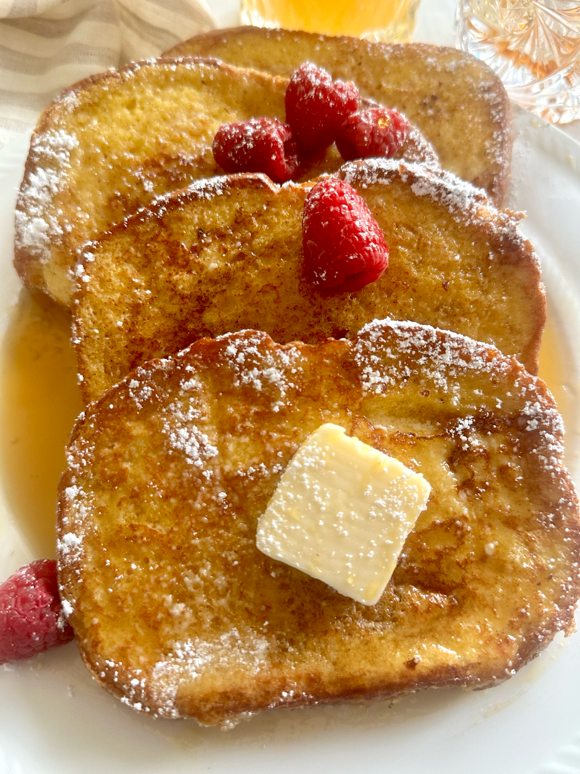 A platter of classic French toast with berries and syrup