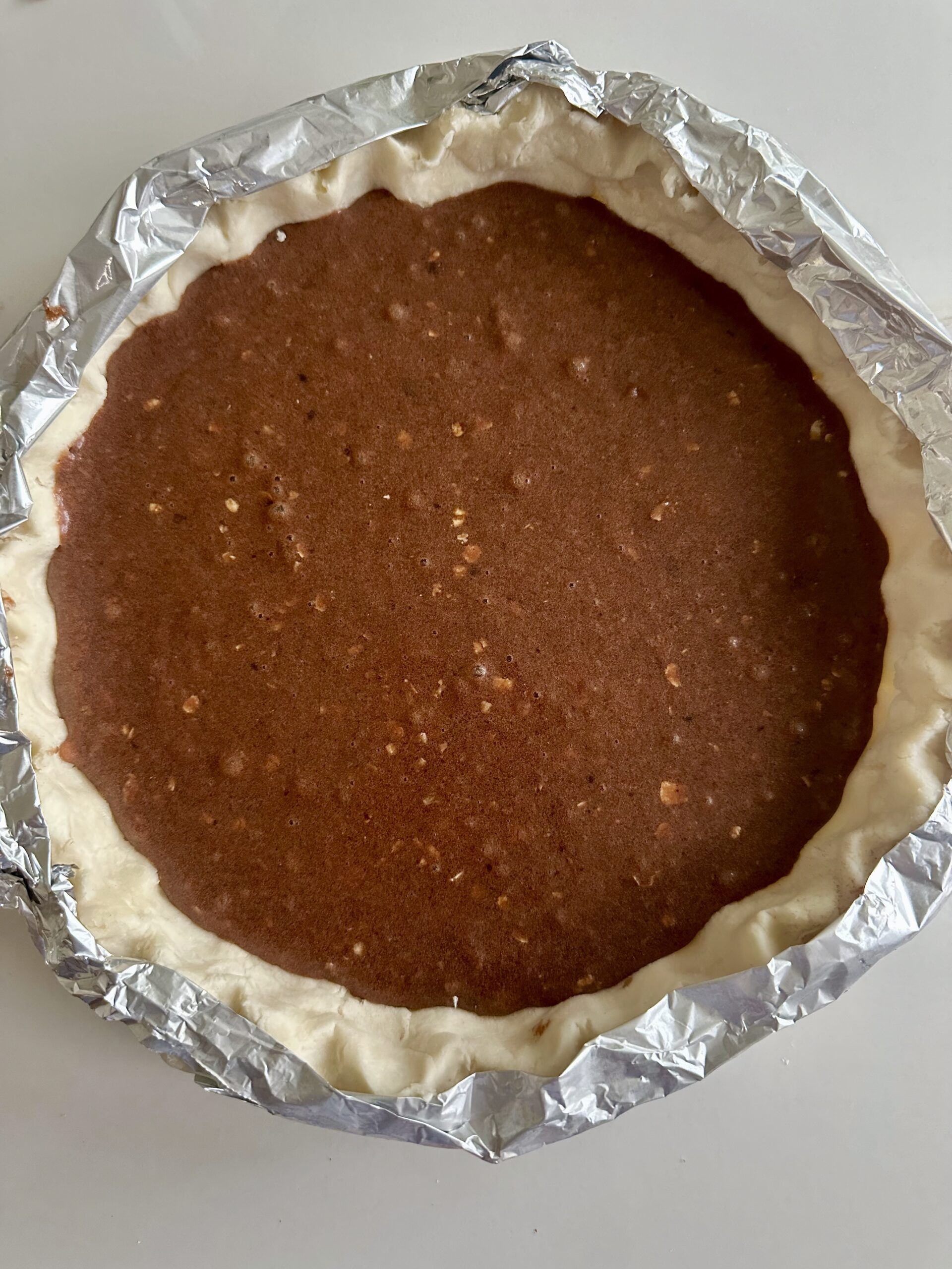 Chocolate fudge filling poured into an unbaked pie shell