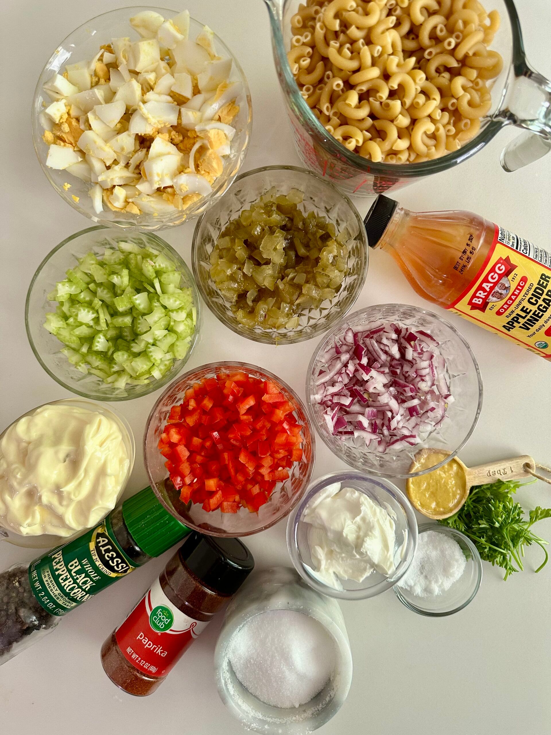 Elbow macaroni, chopped eggs, celery, peppers, onion, pickles, mayonnaise, mustard, and seasonings