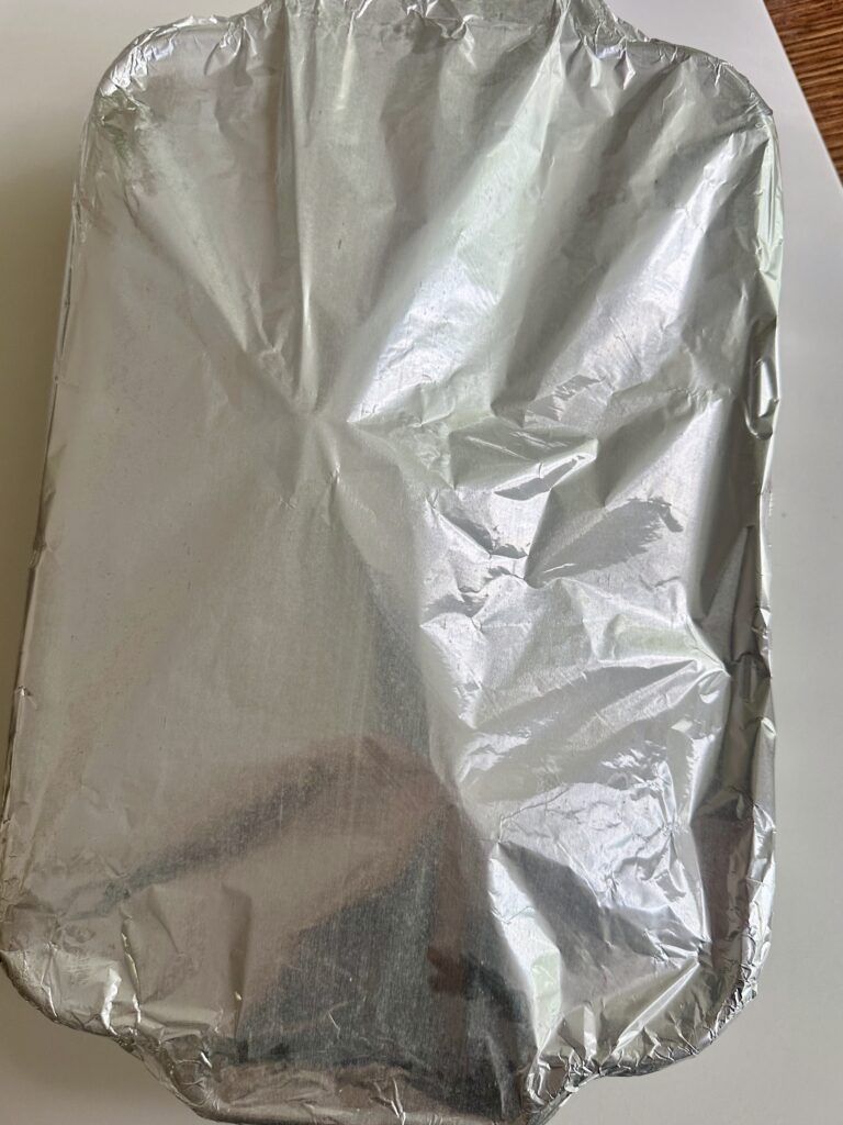 Chicken breasts covered tightly with foil before baking