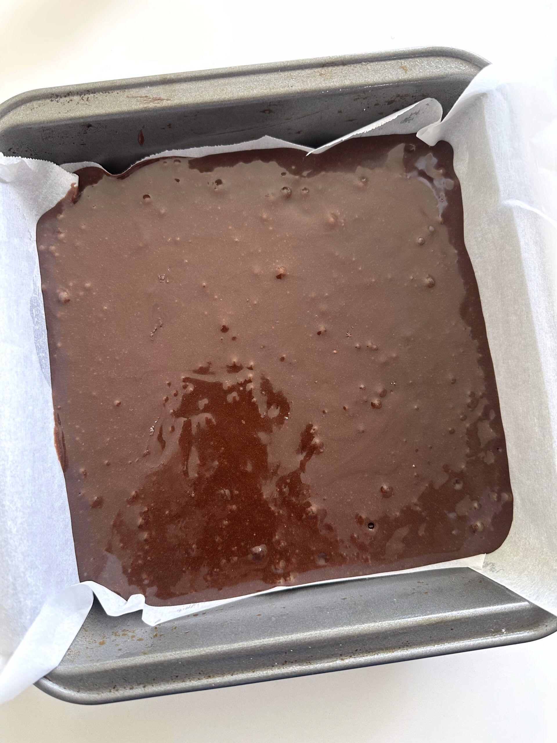 Guinness brownie batter spread in a square baking pan