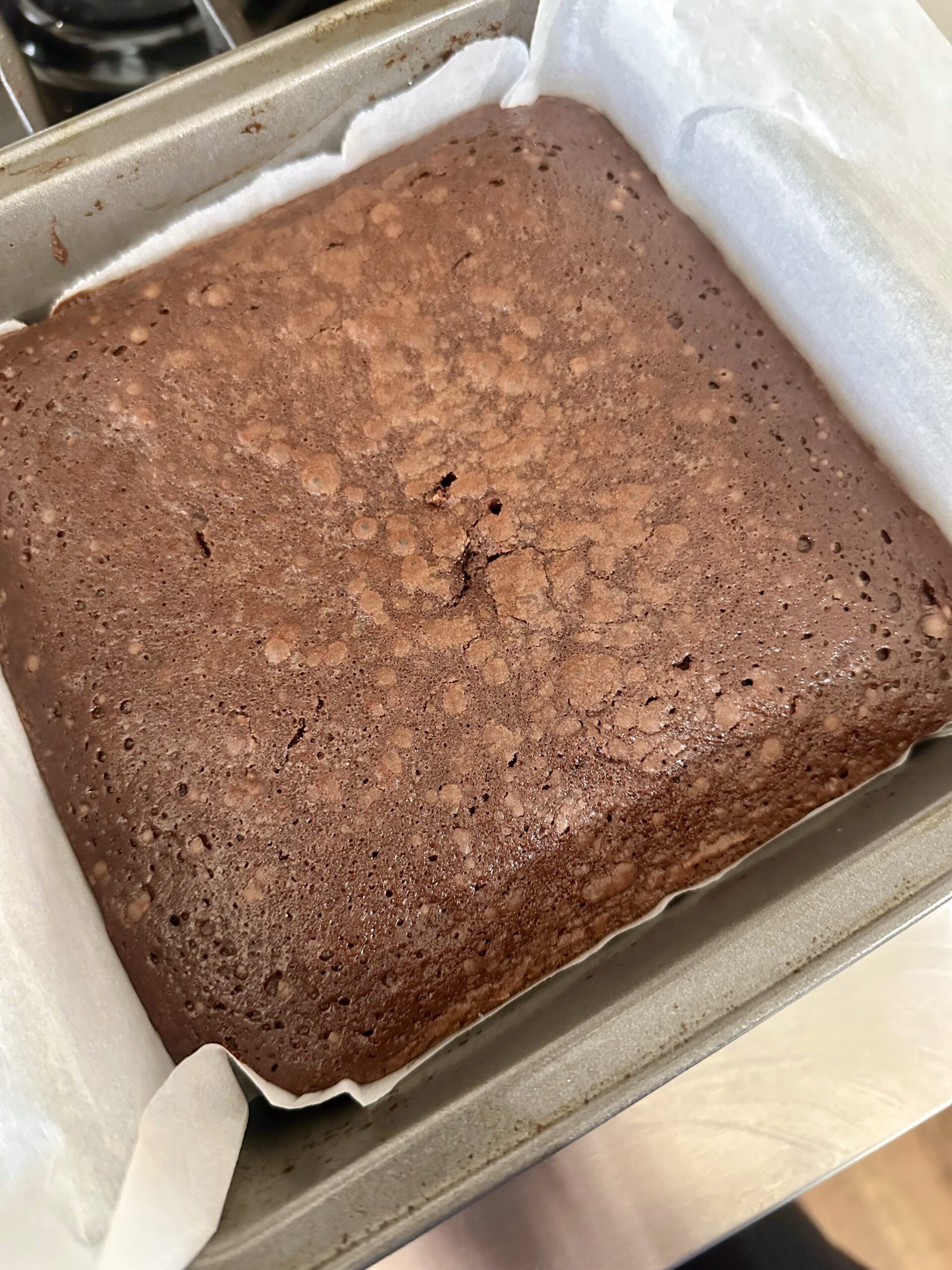 Freshly baked Guinness brownies in a parchment-lined pan