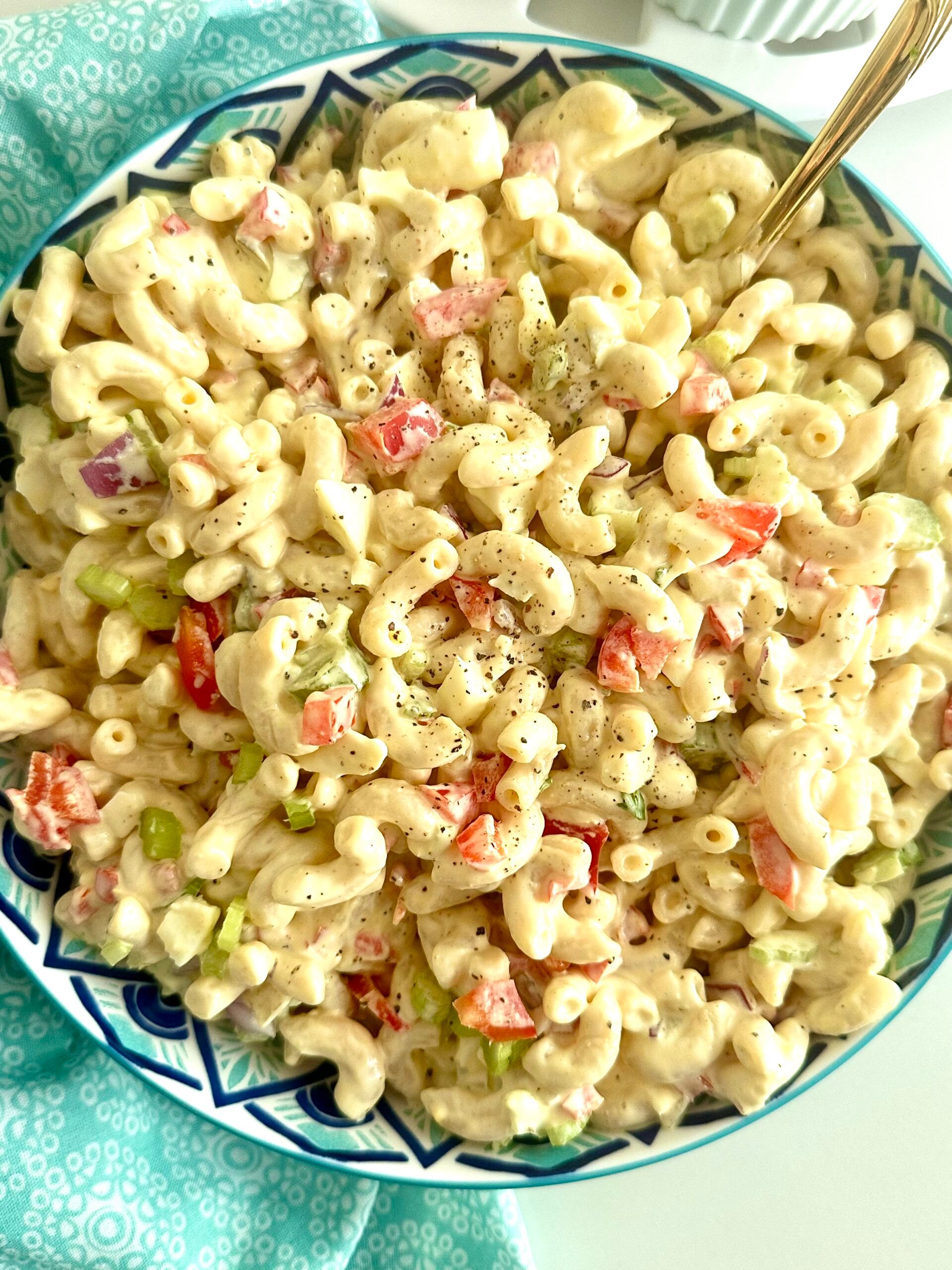 Creamy classic macaroni salad with eggs, celery, and red bell pepper