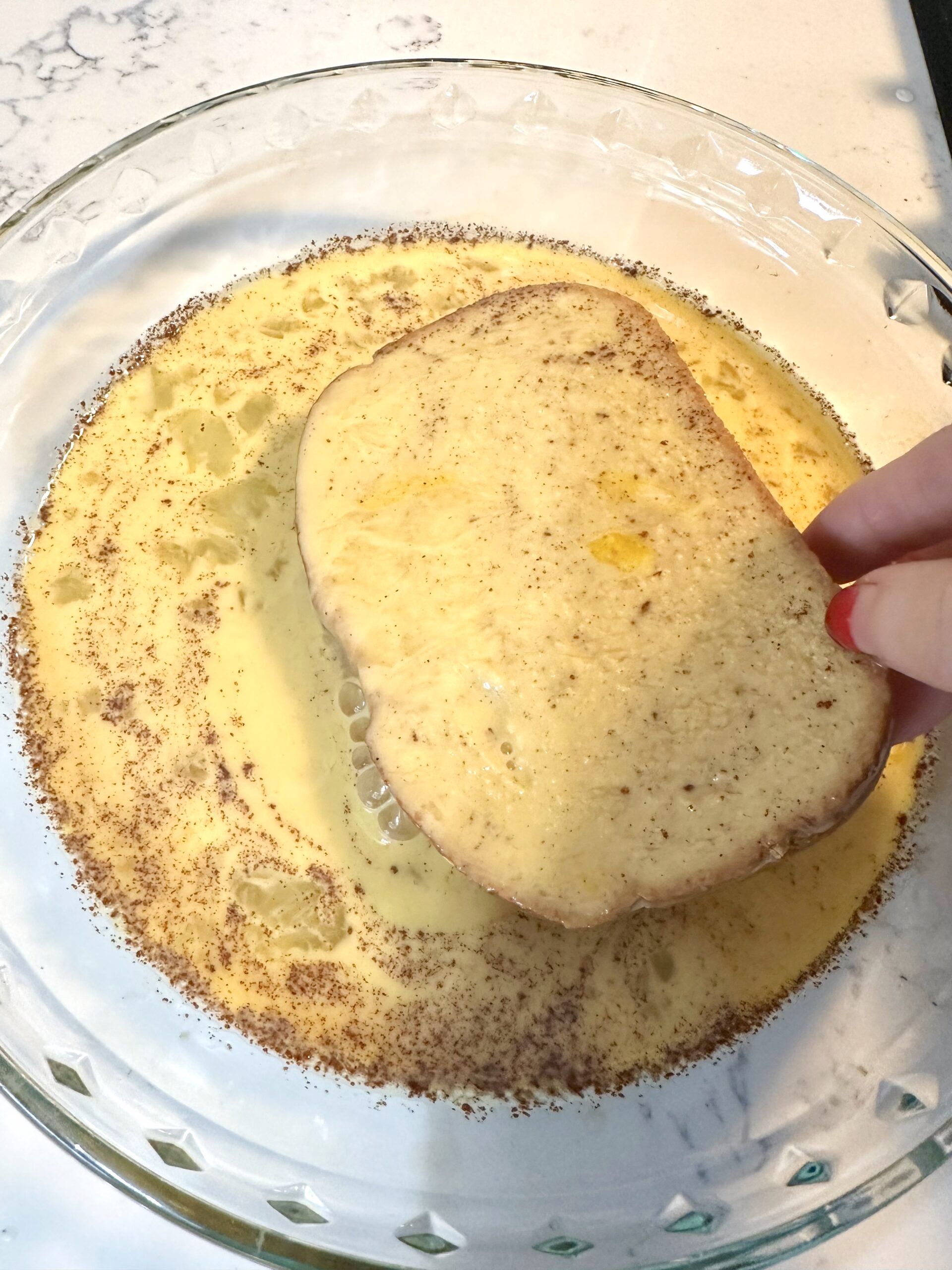 A slice of French toast being turned in the skillet